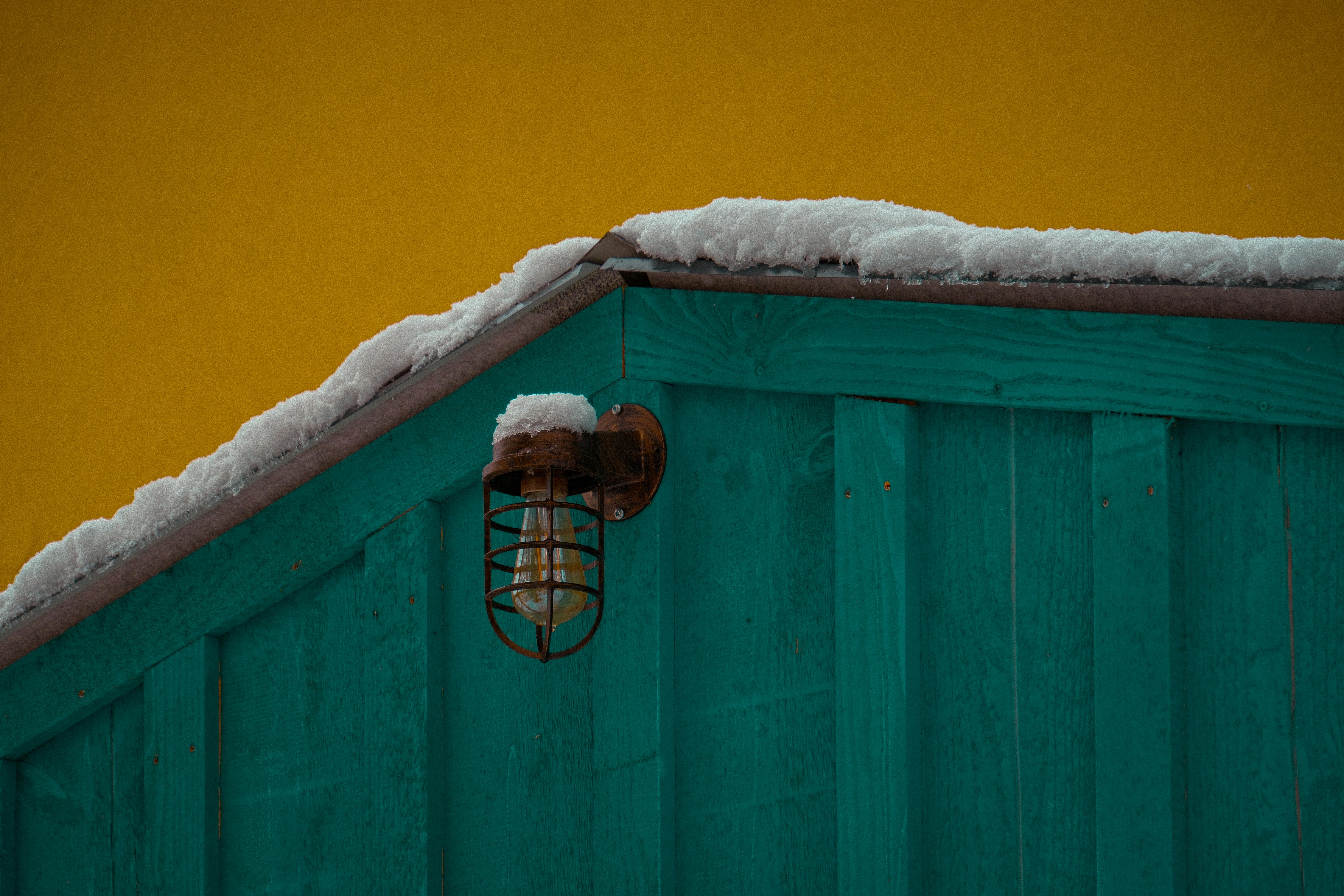 Teal building with snow and yellow sky