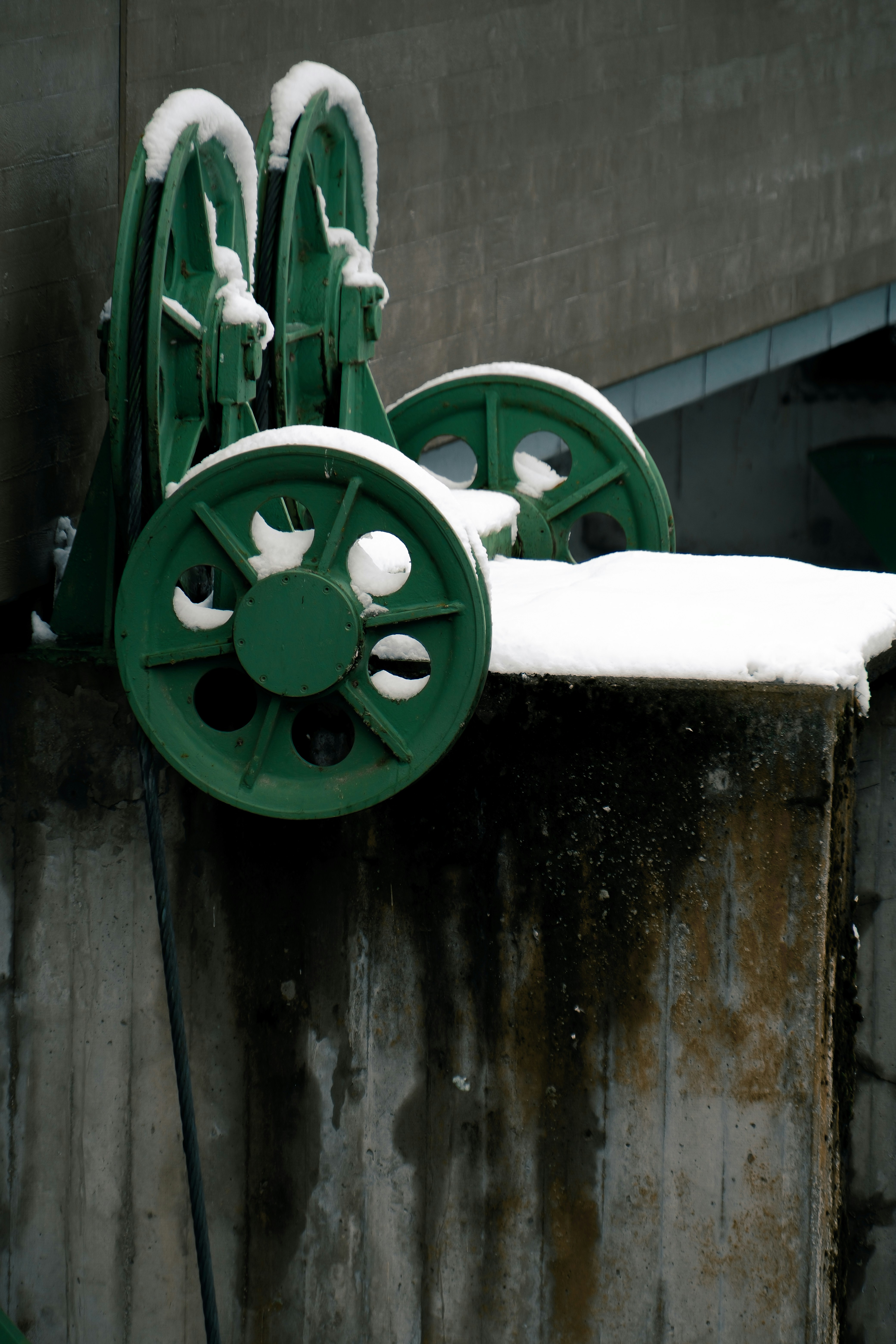 Grüne Industrieräder, die mit Schnee bedeckt sind