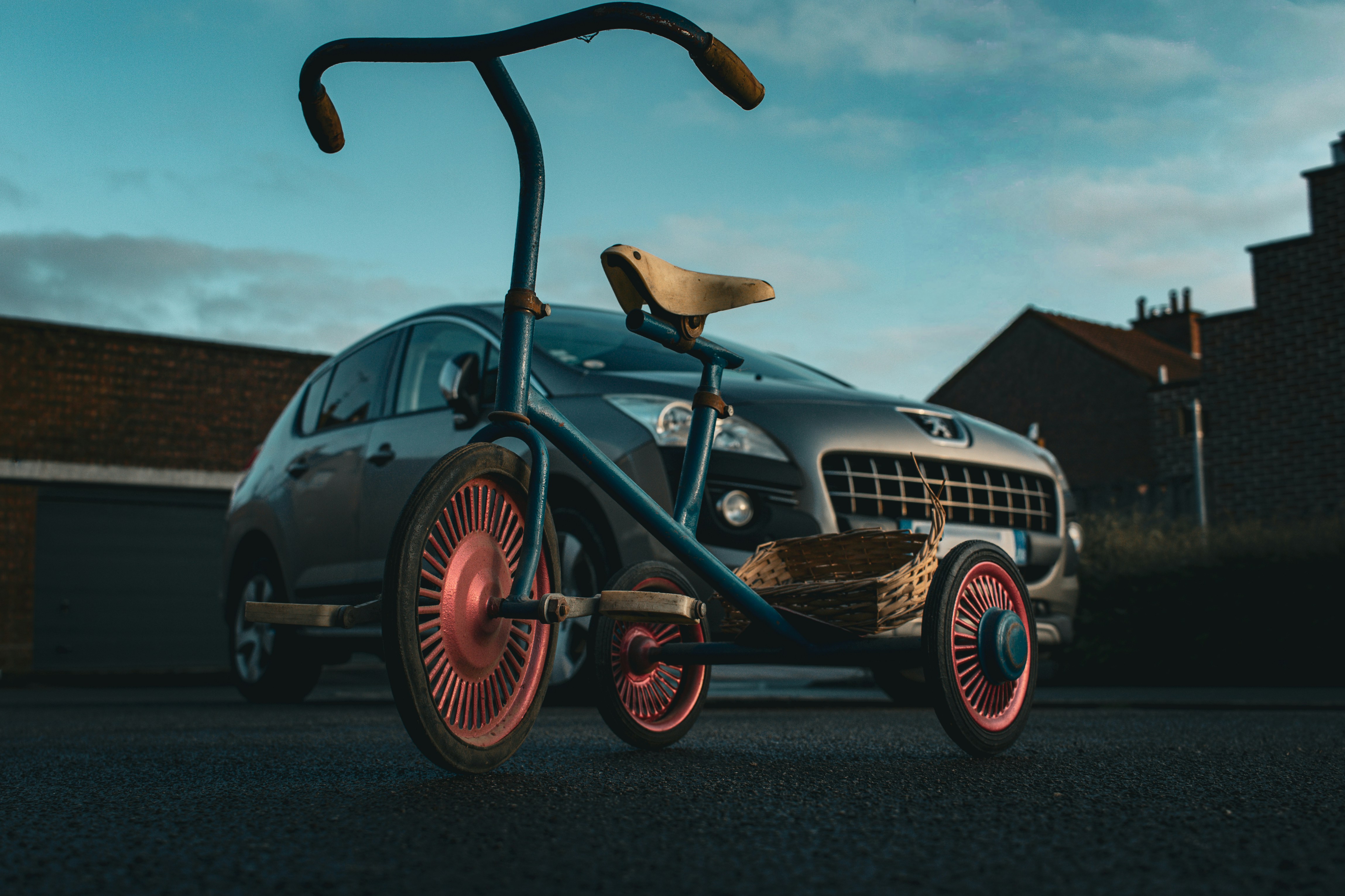 Tricycle vintage garé devant une voiture