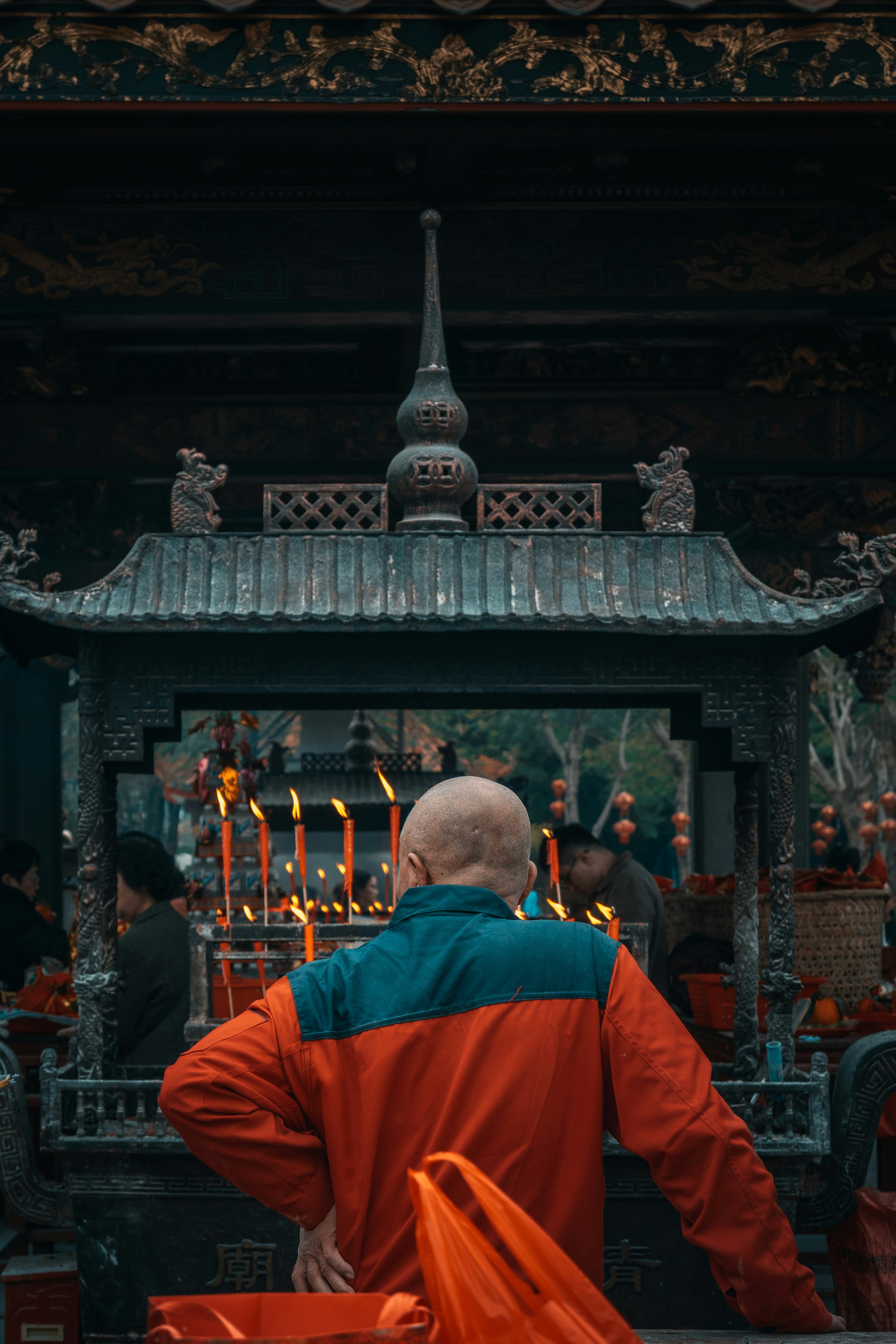 Man praying at an ornate altar with lit candles