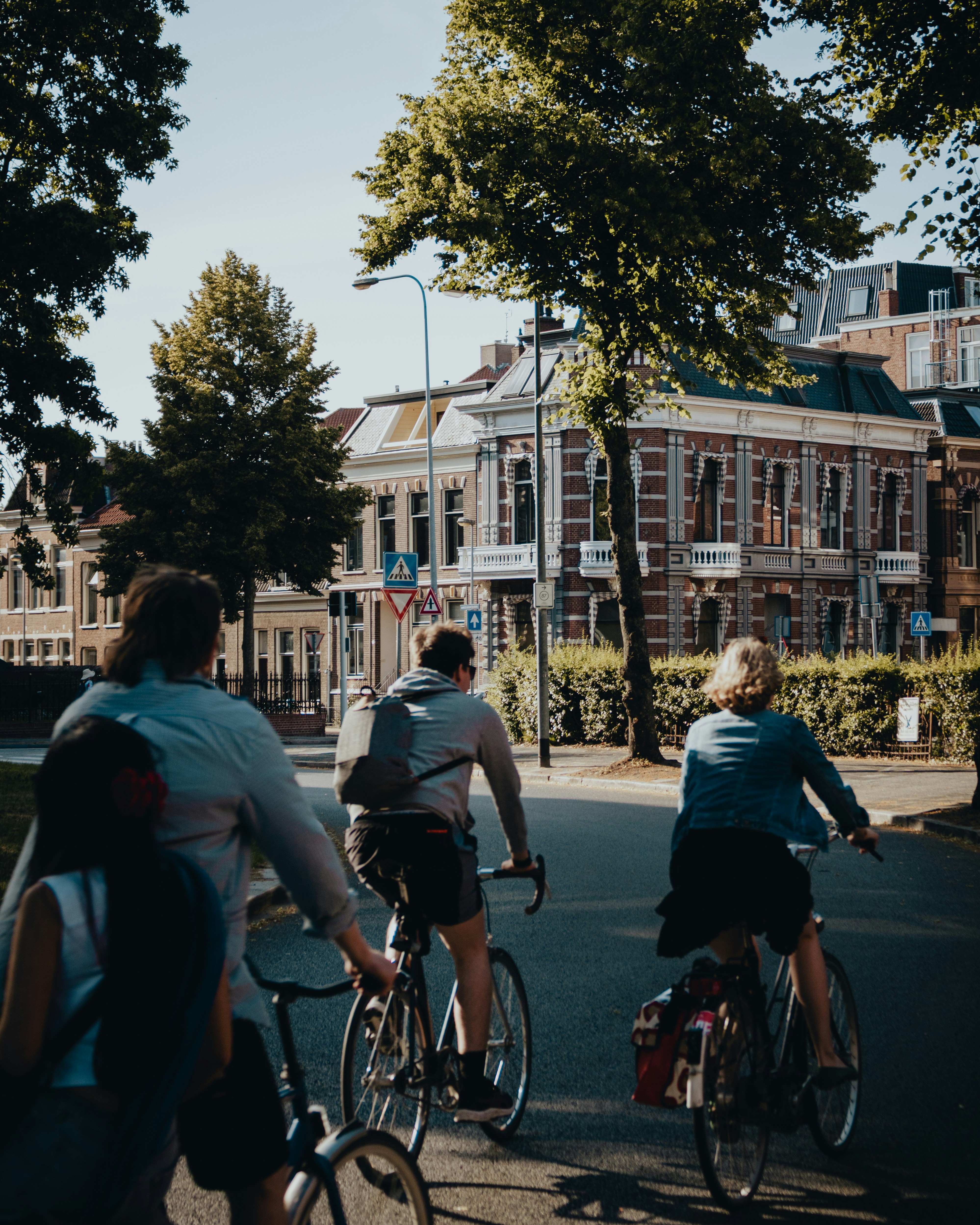 People cycling on a street with buildings.