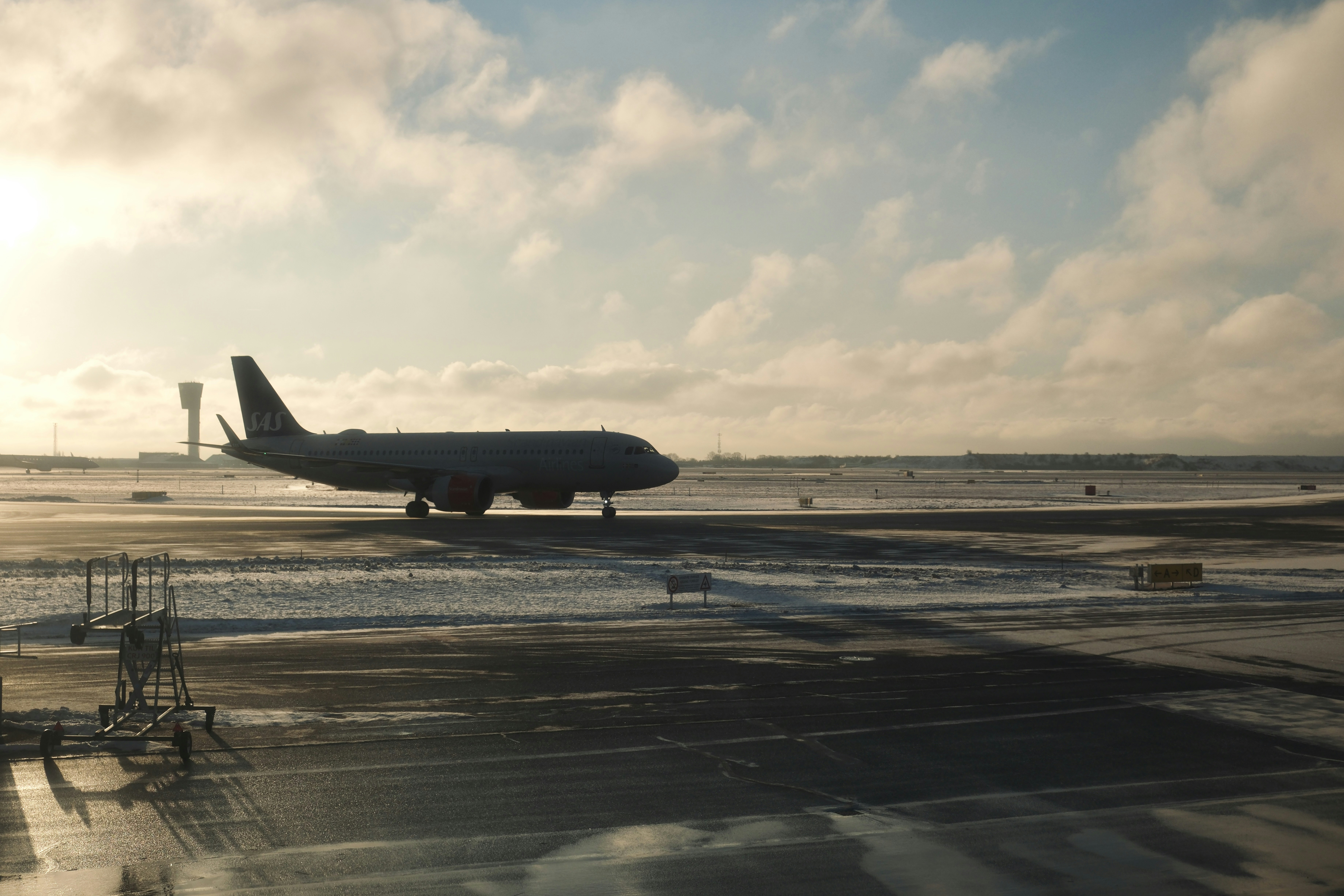 Airplane on a snowy tarmac under a cloudy sky