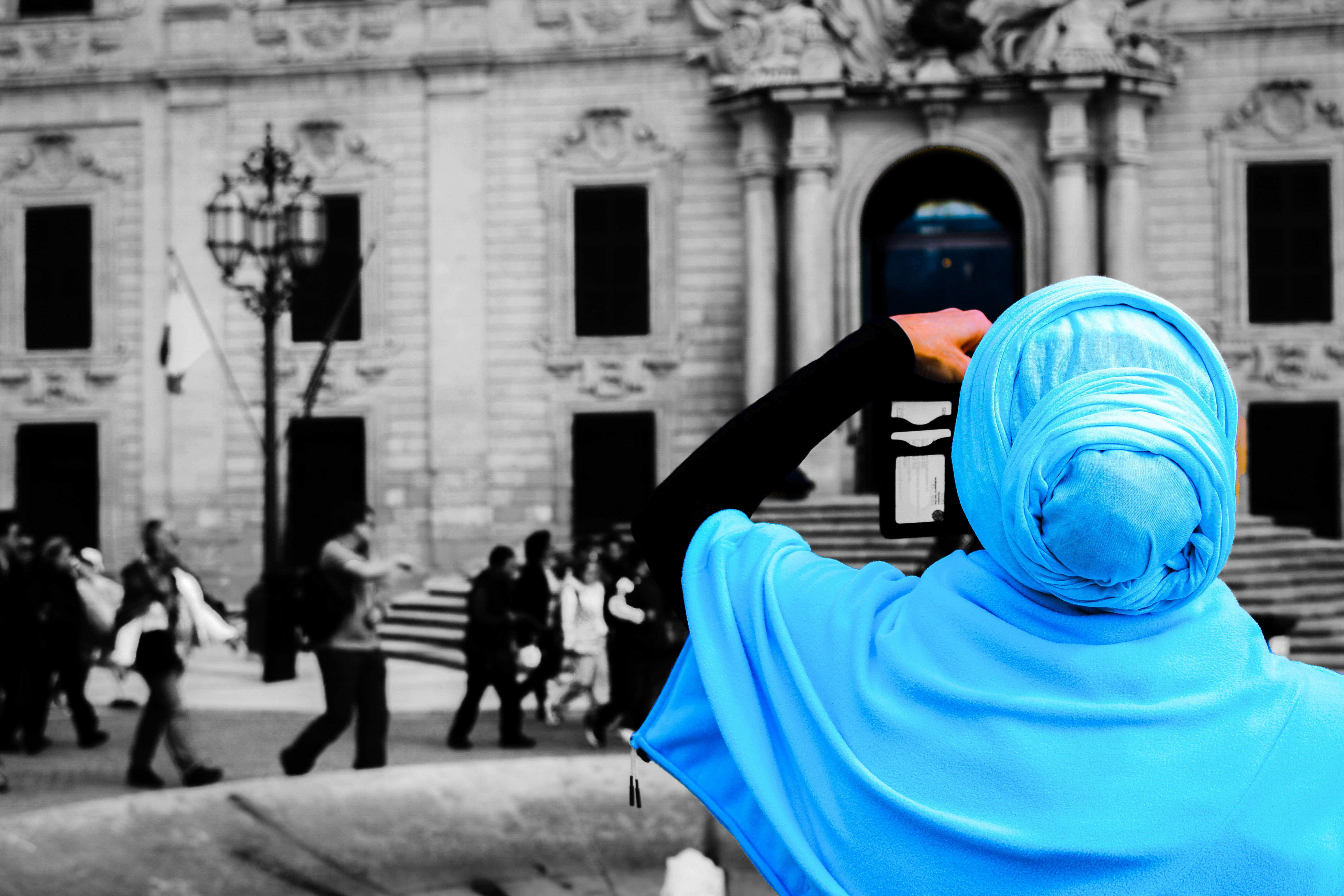 Frau mit blauem Hijab blickt auf das prächtige Gebäude