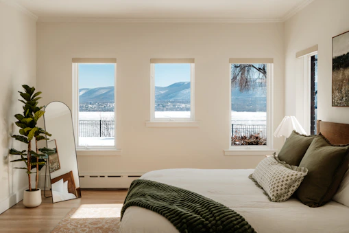 Bedroom with a view of snowy mountains through three windows