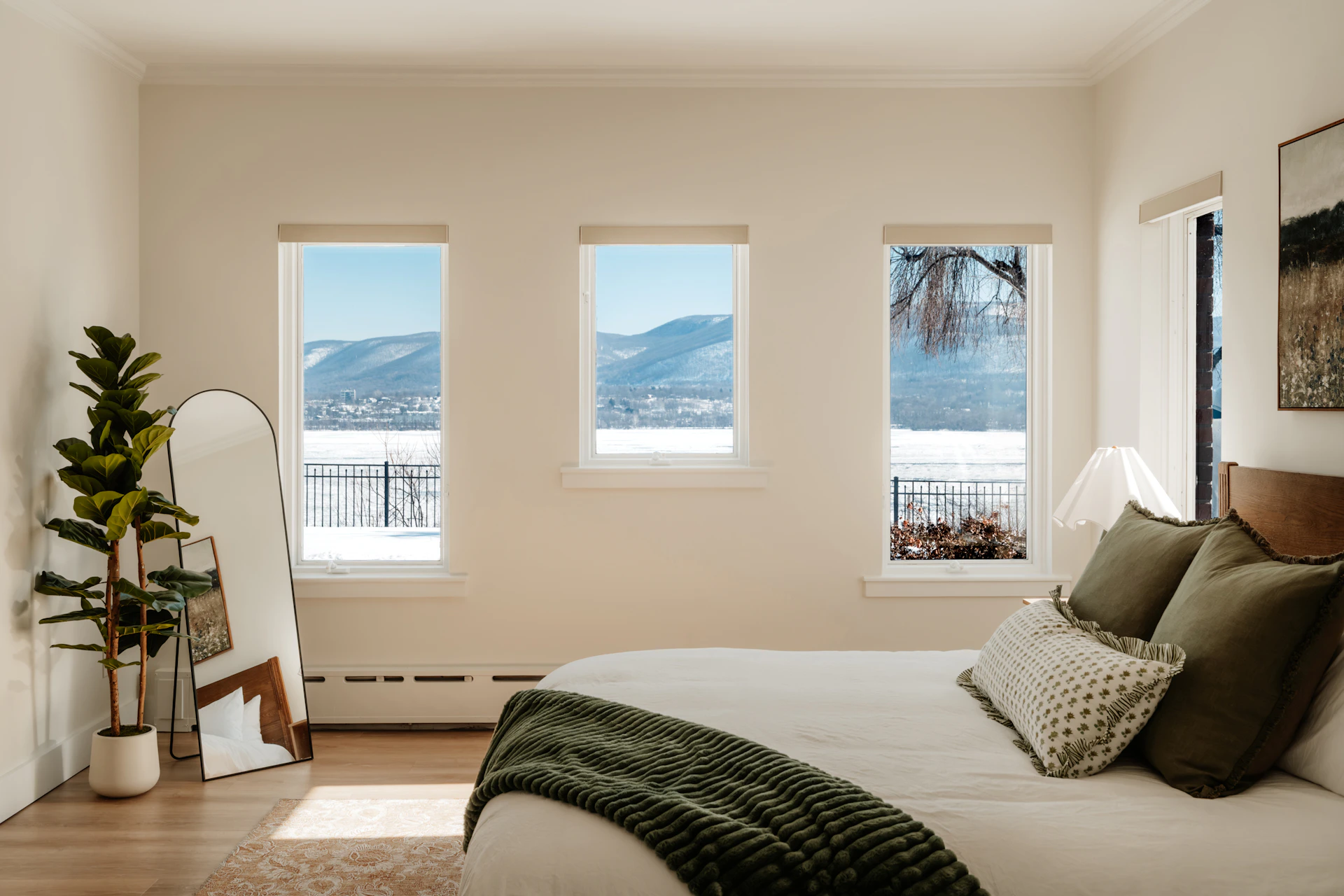Bedroom with a view of snowy mountains through three windows