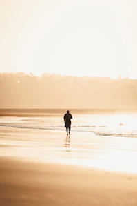 Man walking on a beach at sunset