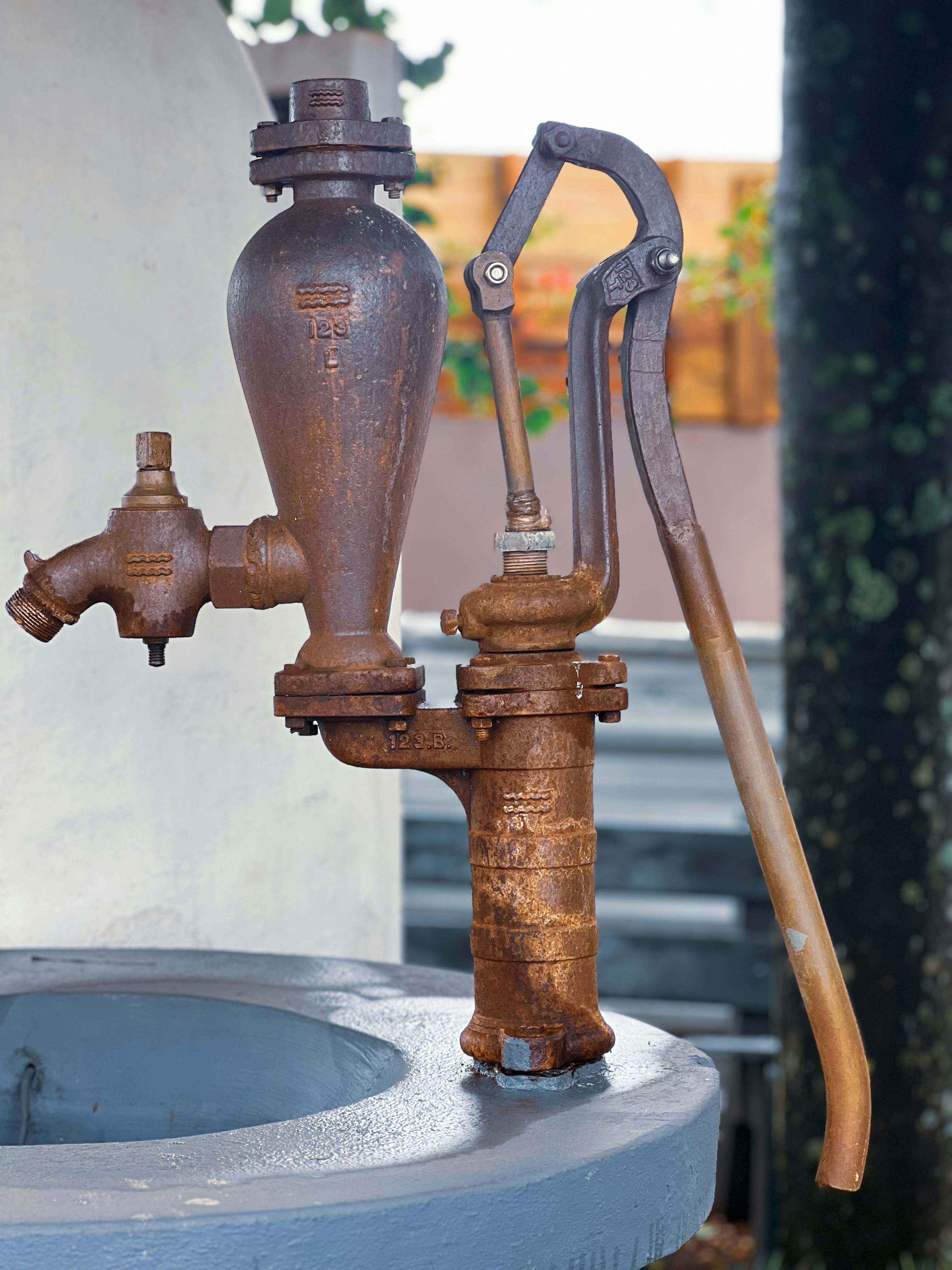 Une vieille pompe à eau rouillée avec un robinet.