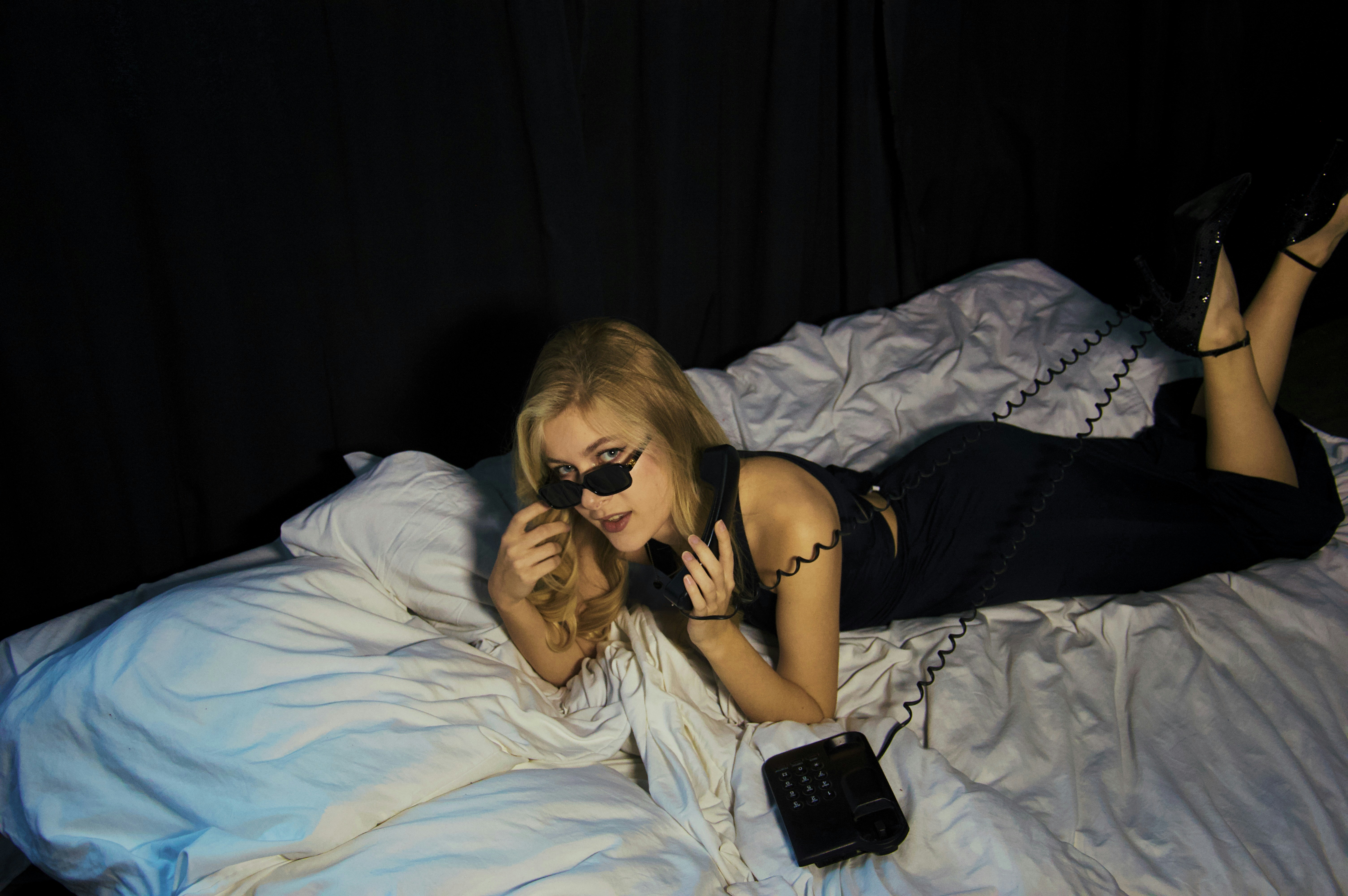 Femme allongée sur son lit avec son smartphone