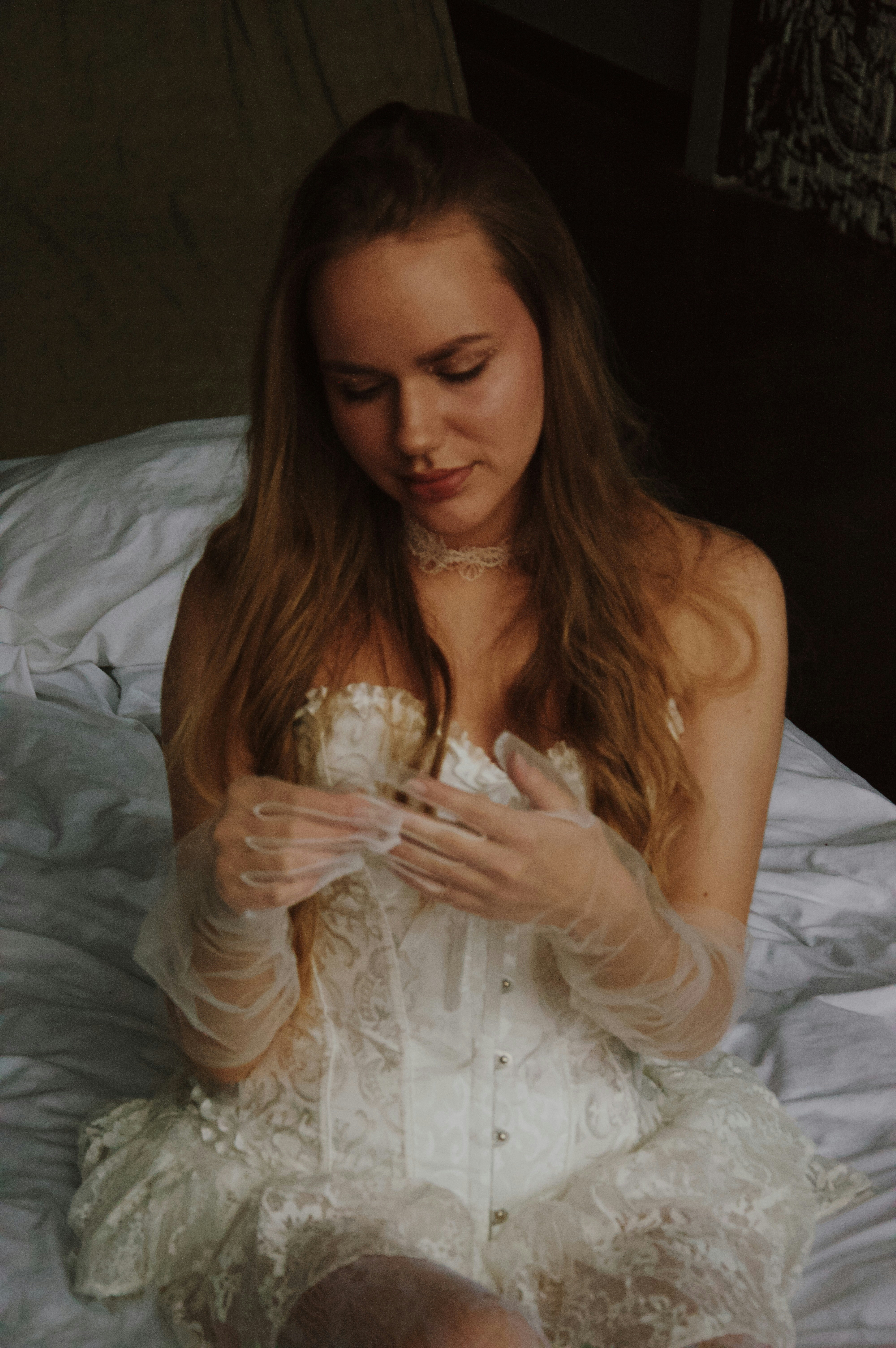 A young woman in a white corset and gloves