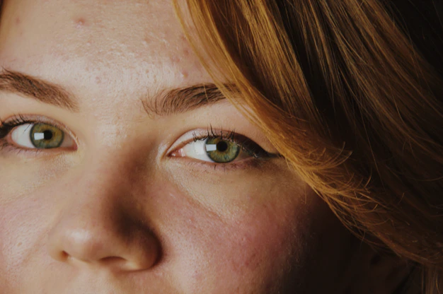 Close-up of a woman's green eyes and face