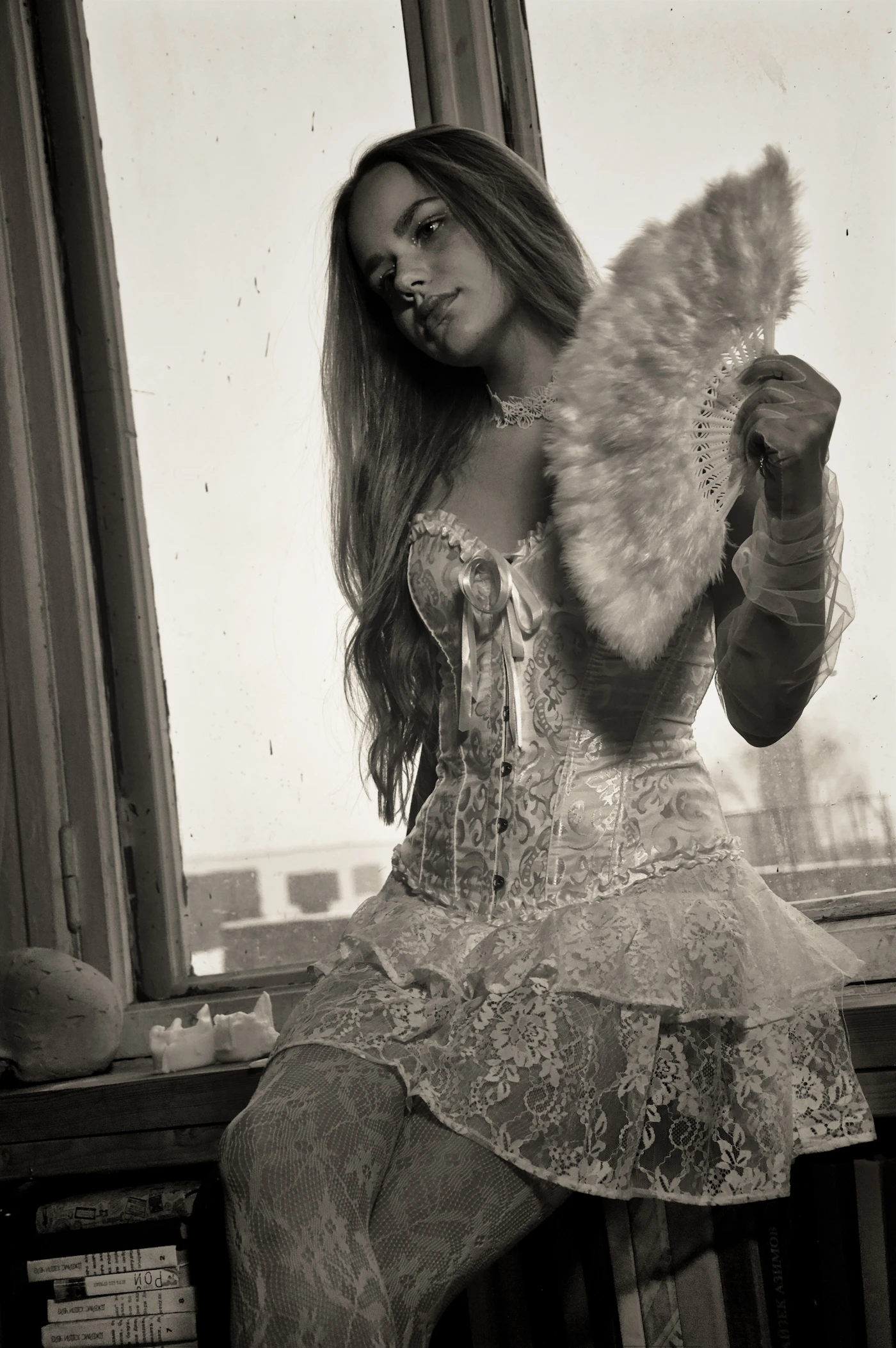 Burlesque performer in corset holding a feather fan