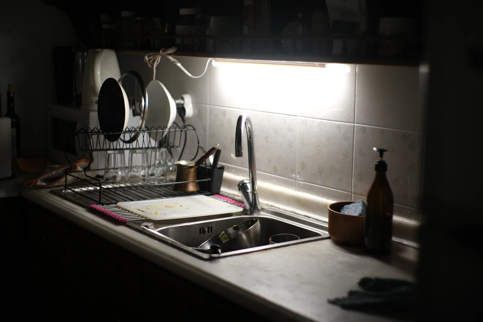 Clean dishes drying beside a small kitchen sink