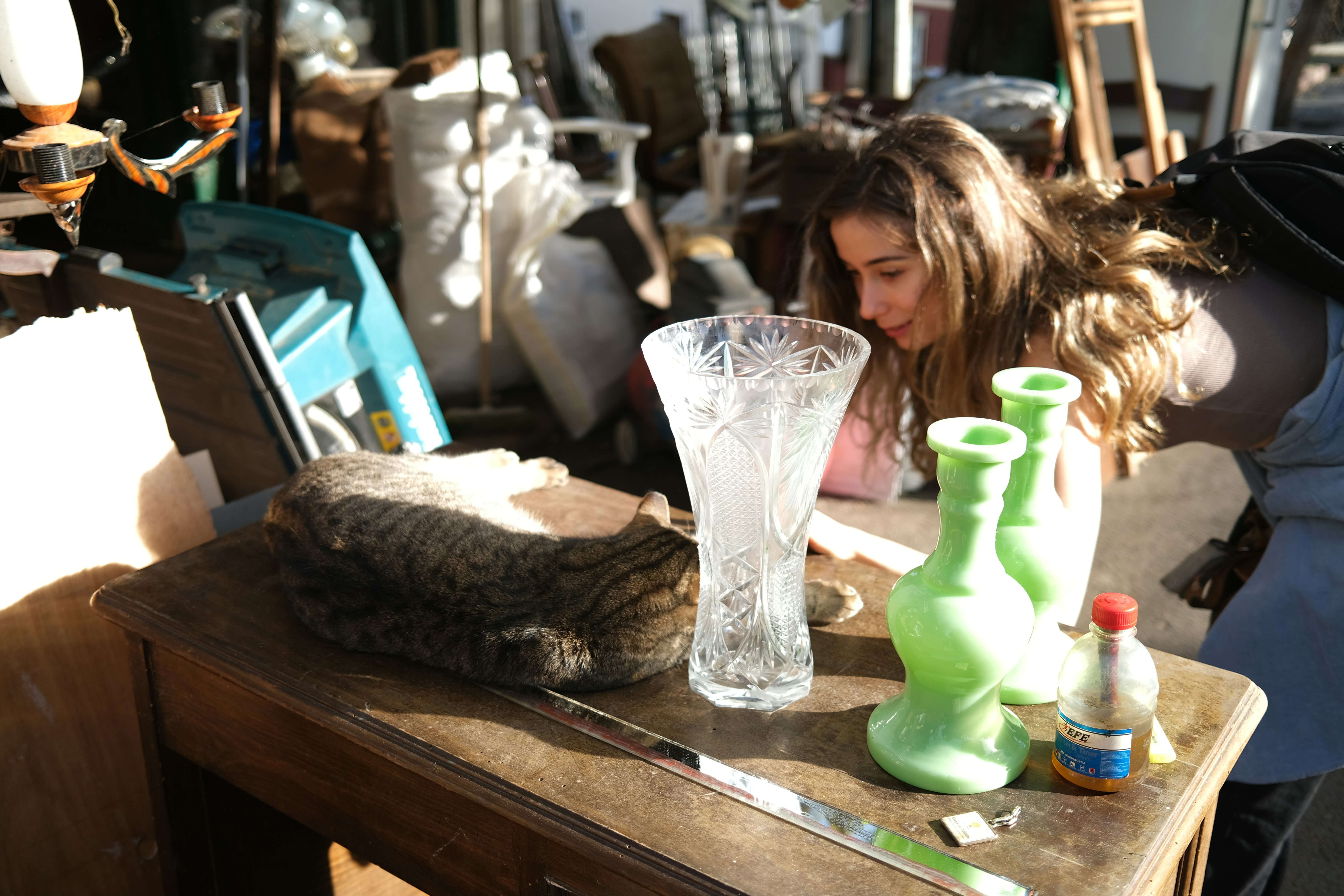 Young woman and cat among cluttered items
