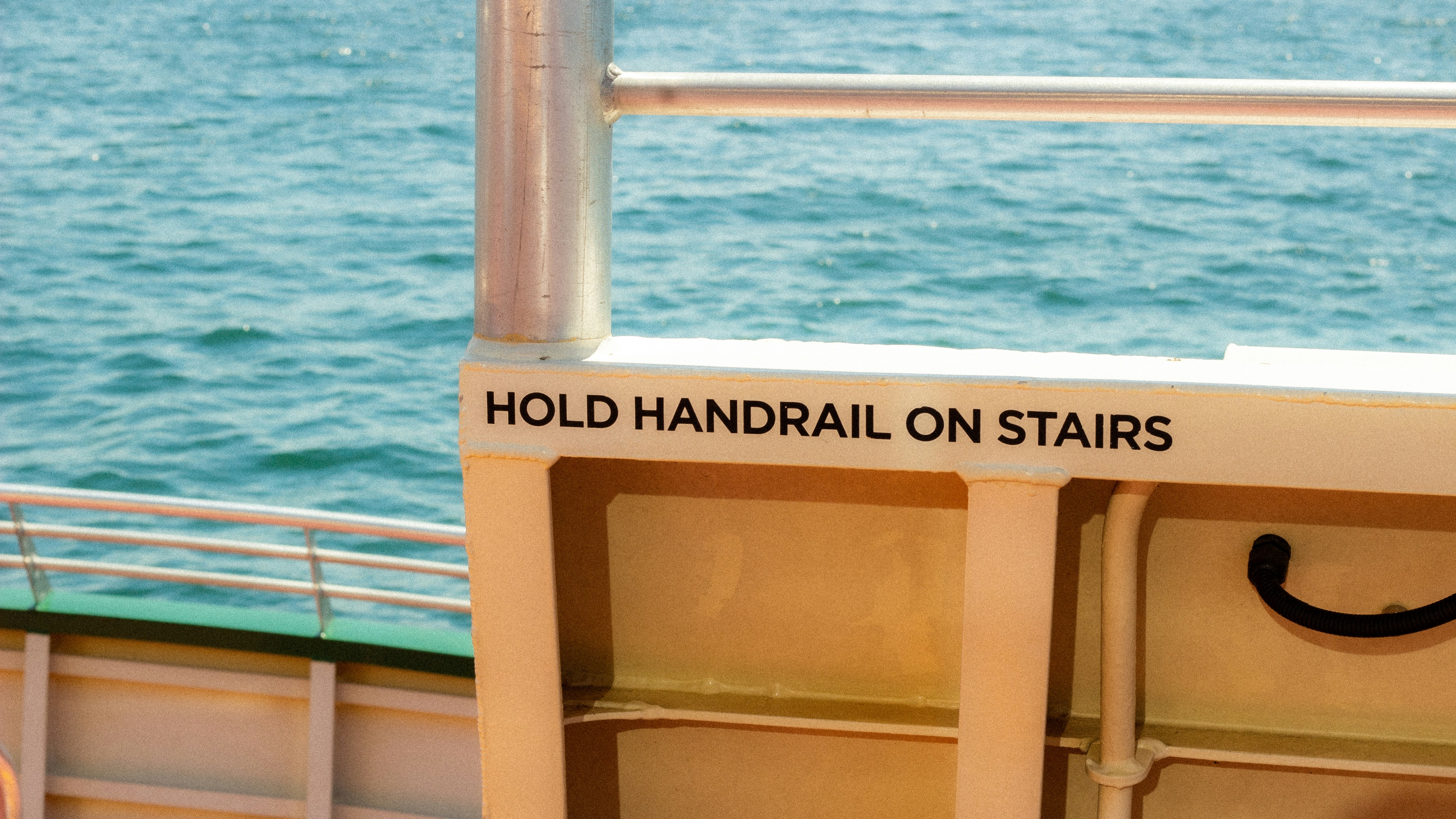 Hold handrail on stairs sign on a boat.