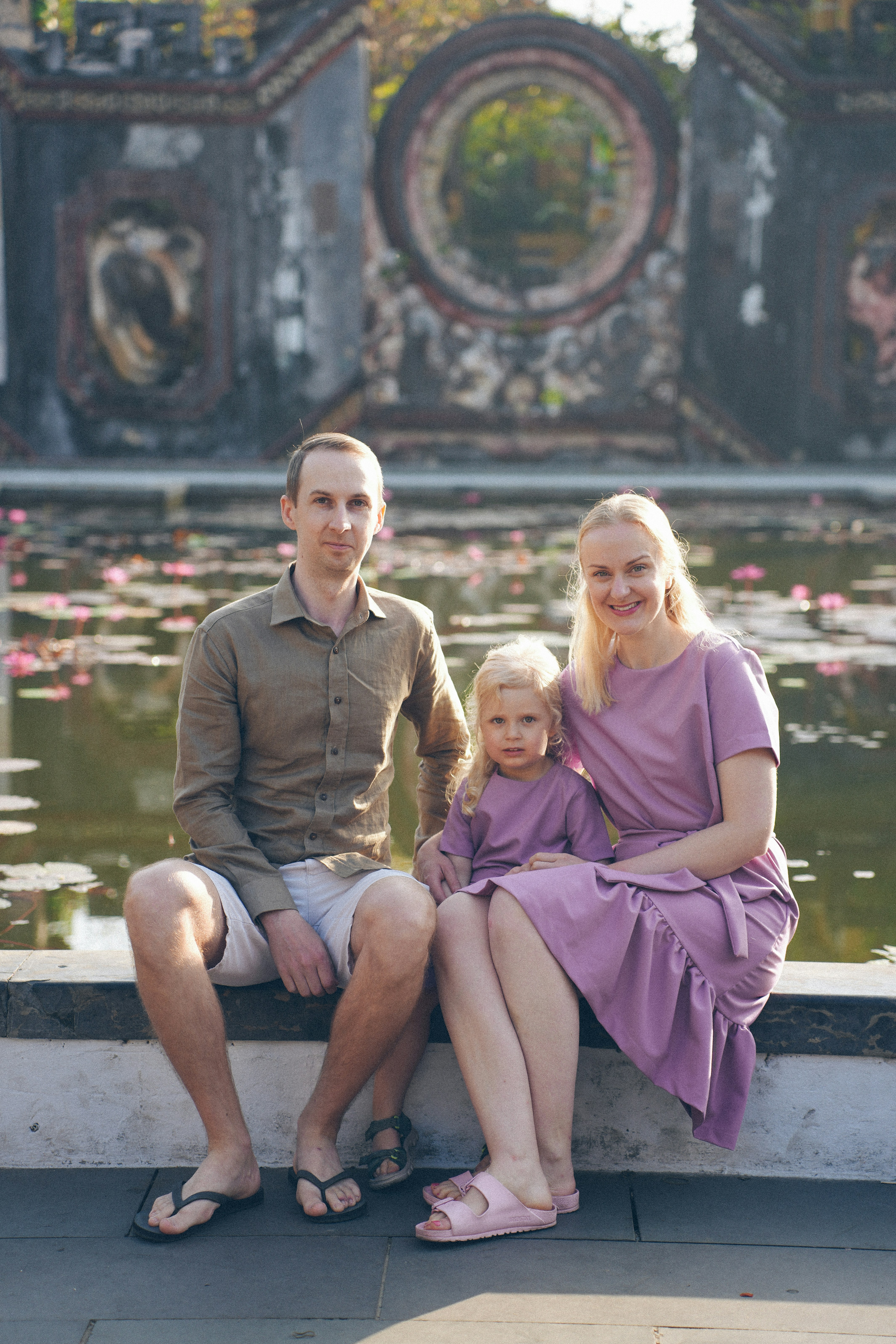 A family sits by a pond with lily pads. photo - Free Travel Image on ...