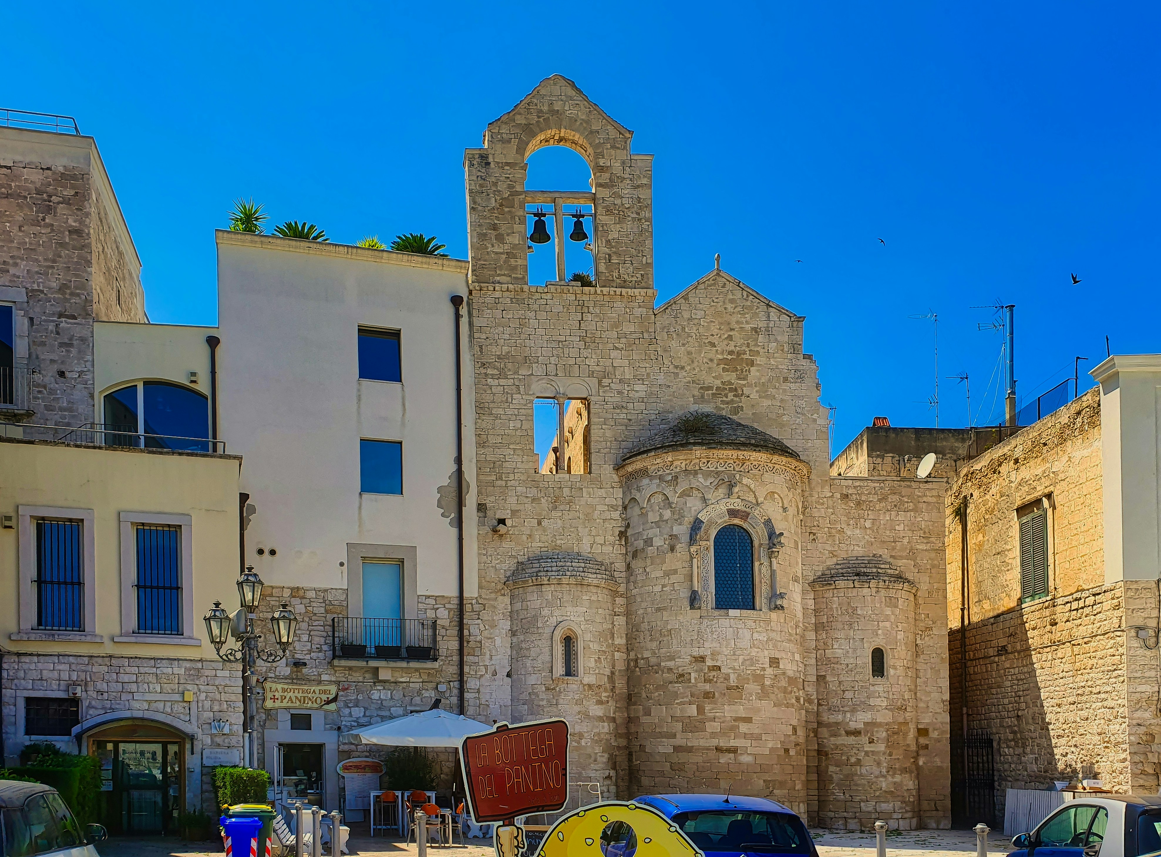 Ancient stone church ruins against a bright blue sky.