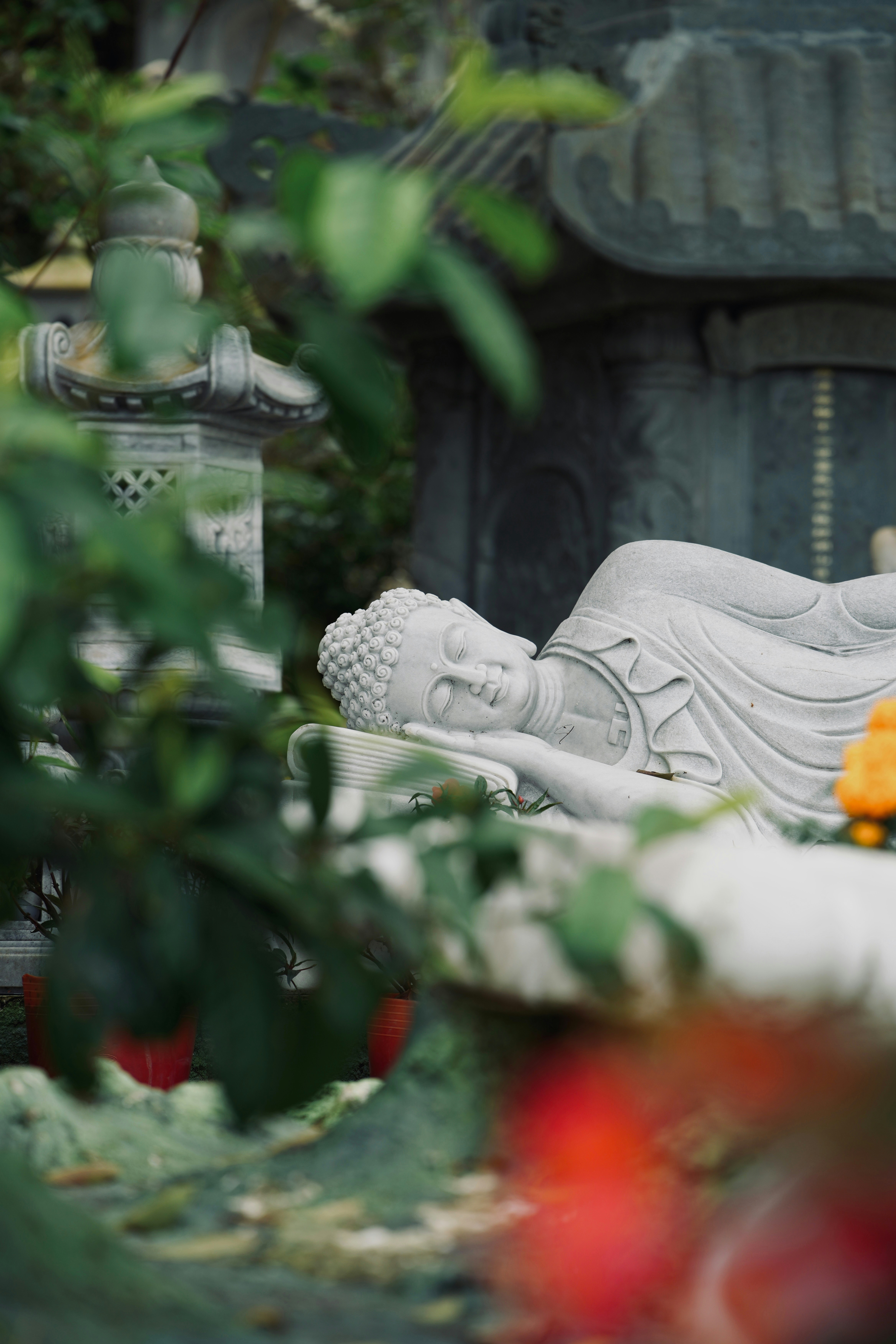 Liegende Buddha-Statue in einer ruhigen Gartenkulisse.