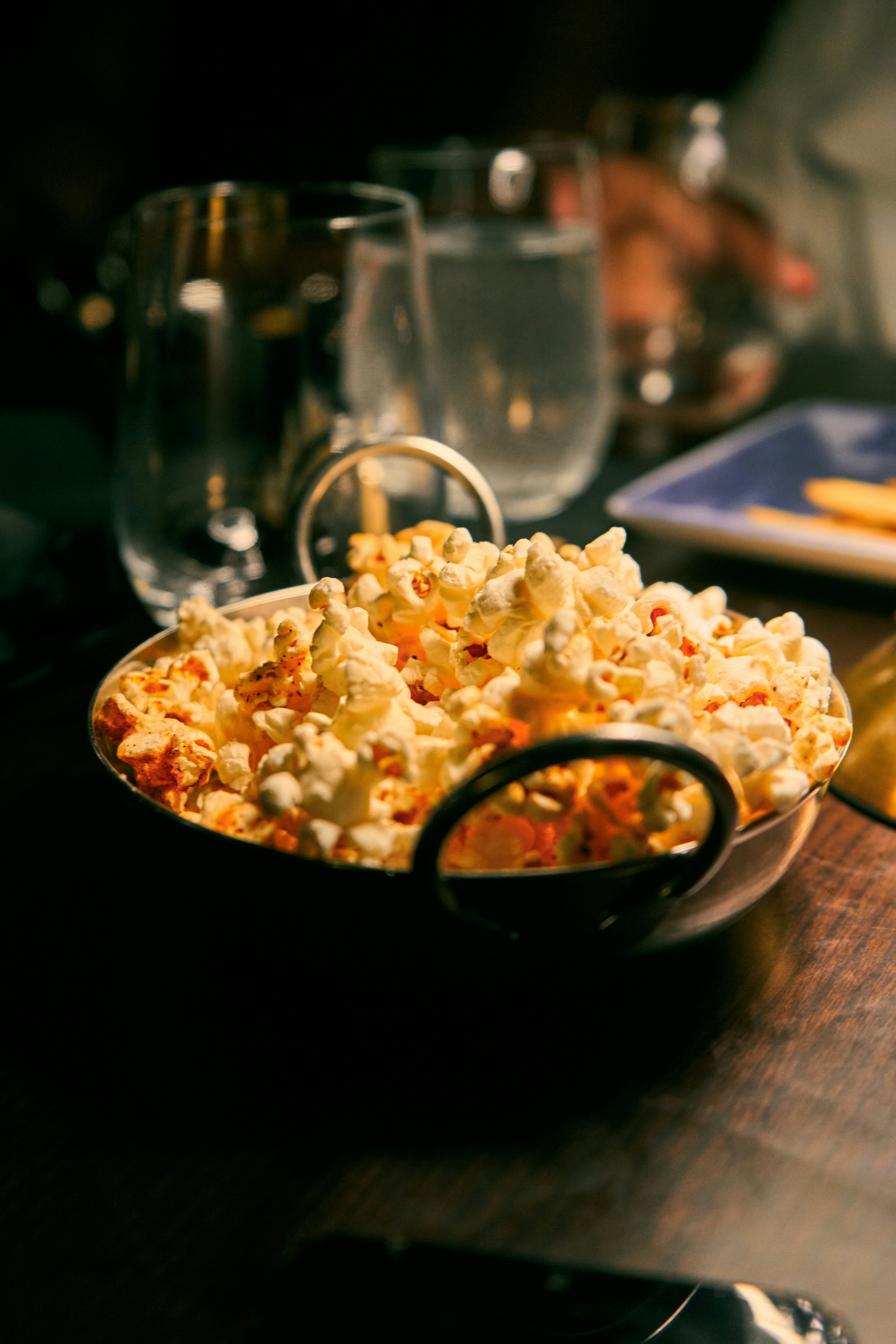 Bowl of popcorn on a table with drinks