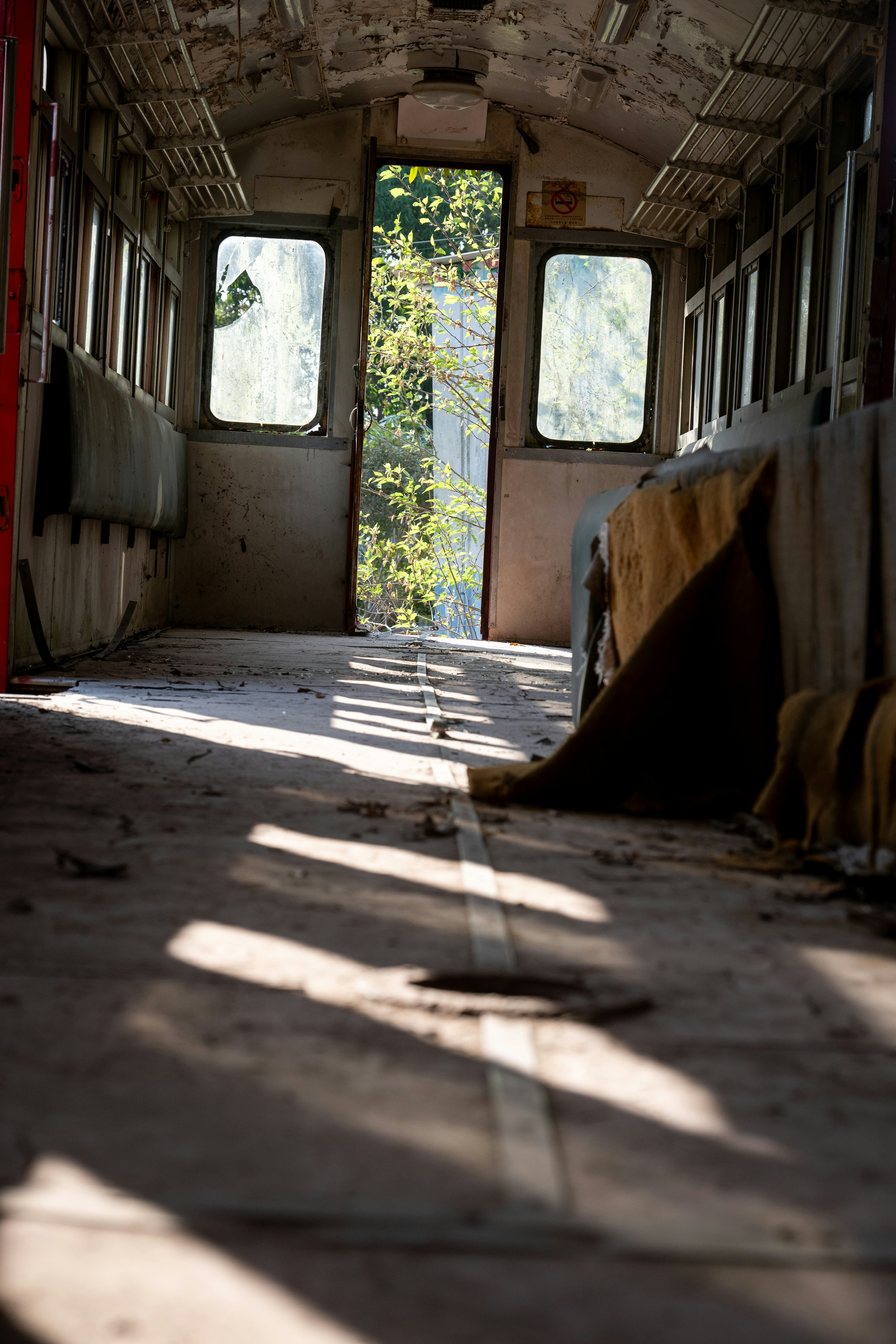 Interior of abandoned train car with sunlight streaming in.
