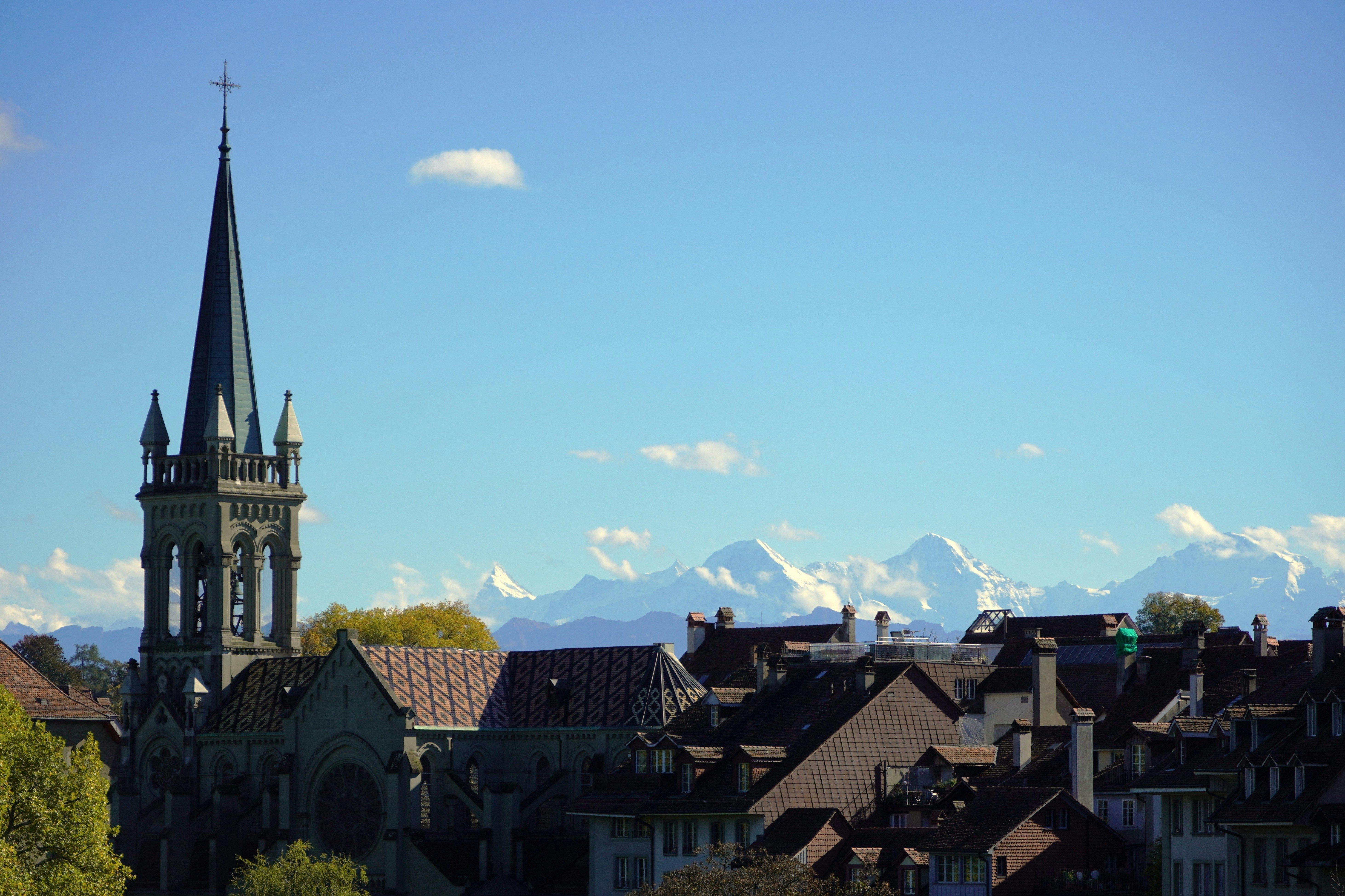 Church steeple with distant snow-capped mountains