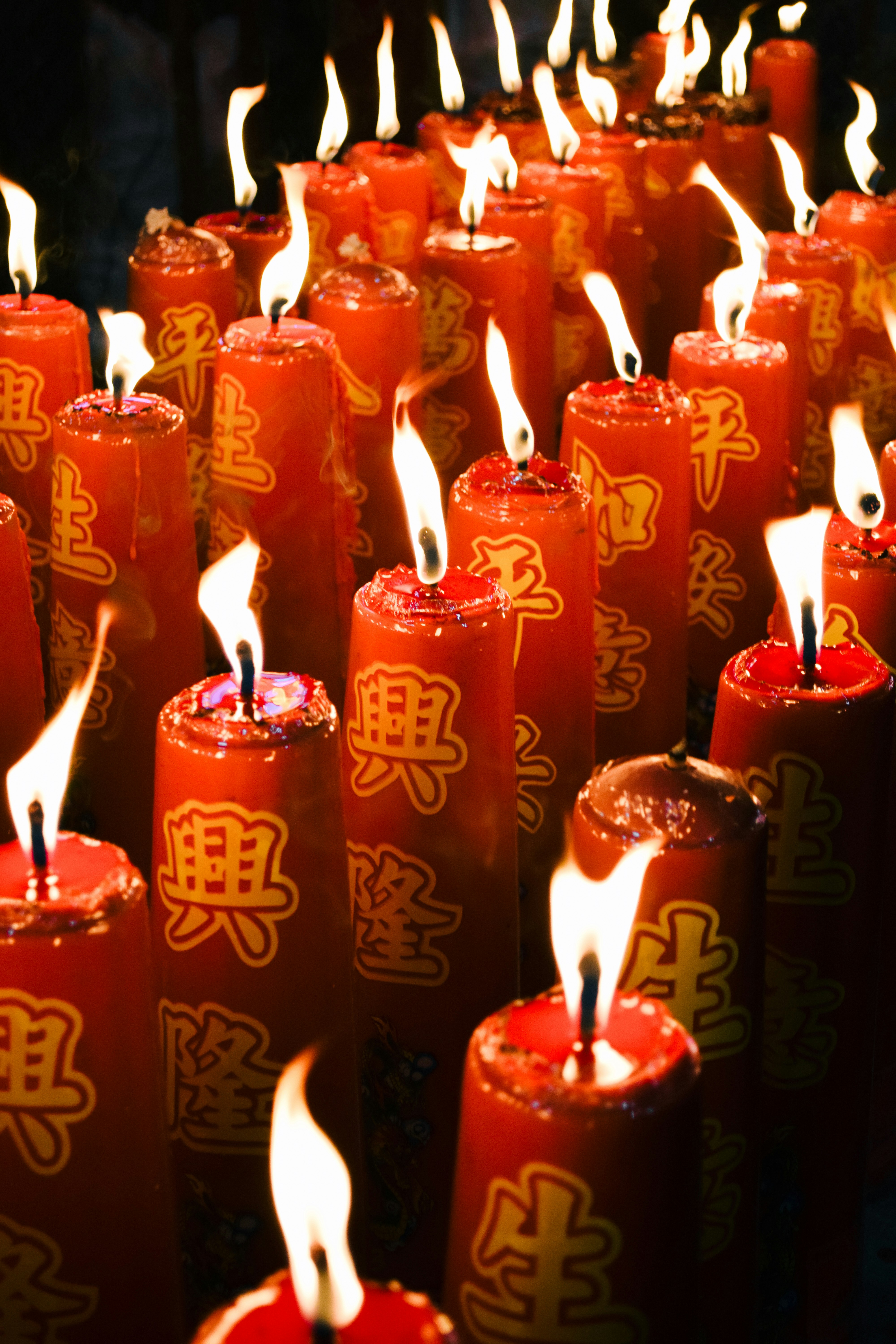 Viele rote Kerzen mit chinesischen Schriftzeichen brennen