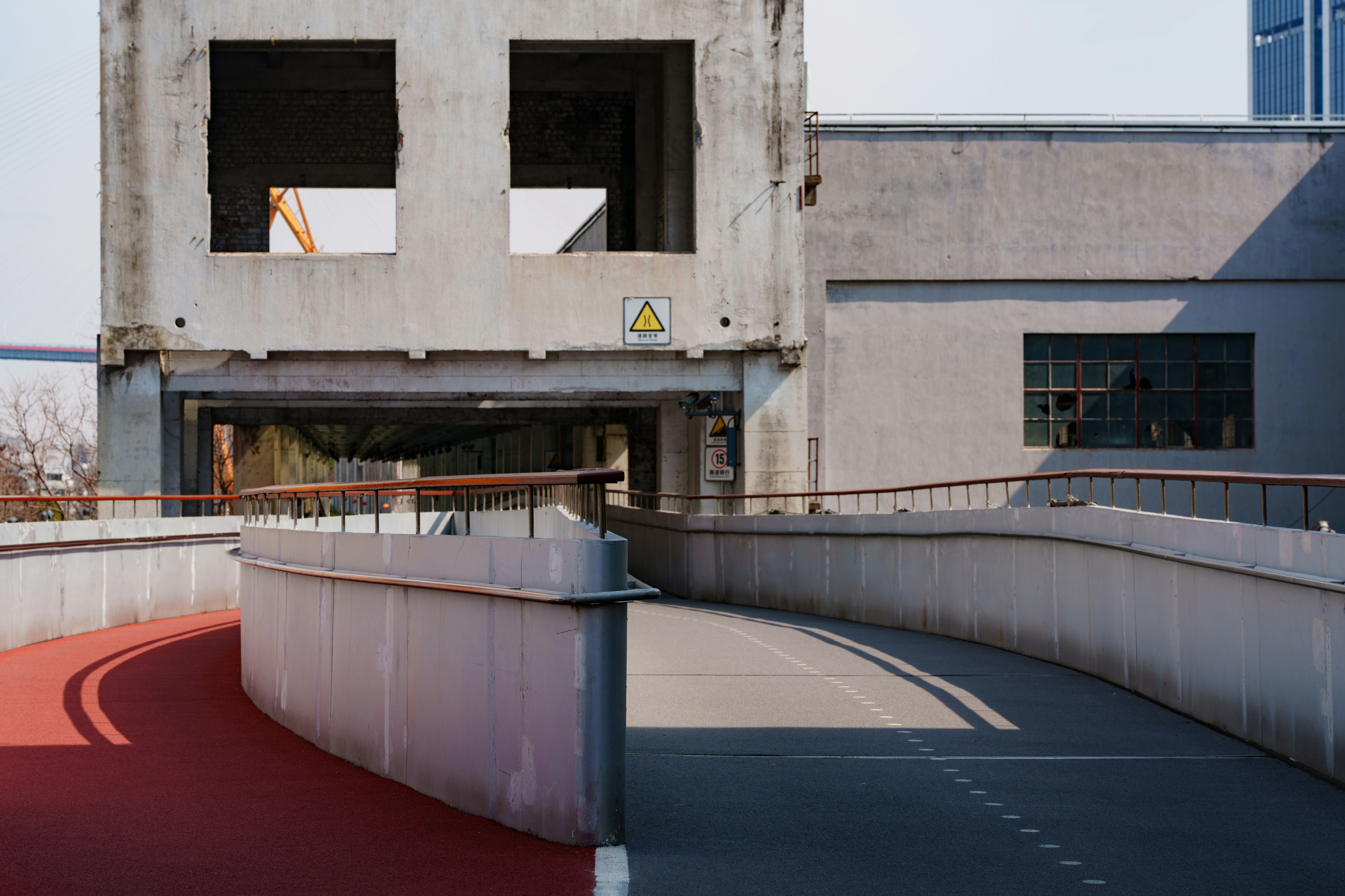 An abandoned concrete building with a curved walkway