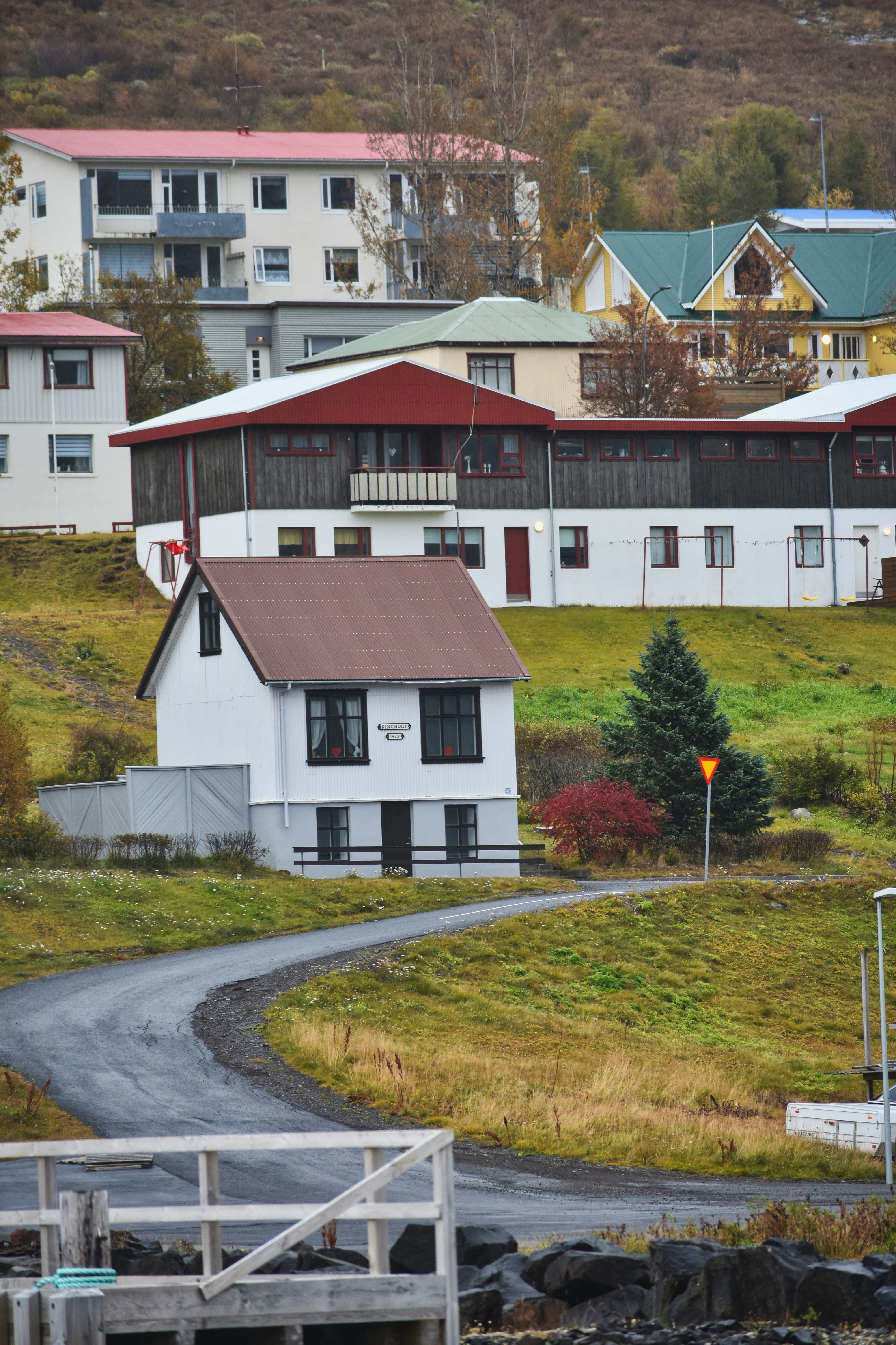Eine kurvenreiche Straße führt zu Häusern an einem Hang.
