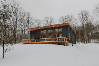 Modern house with wooden deck in snowy landscape