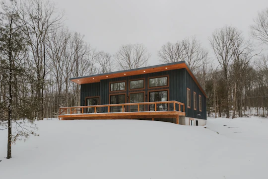Modern house with wooden deck in snowy landscape