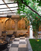 Outdoor patio seating area with checkered floor and plants.