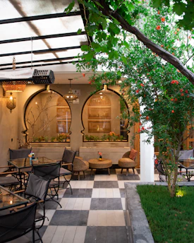 Outdoor patio seating area with checkered floor and plants.