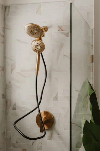 Gold shower head with black hose in modern bathroom in Phoenix, Az.