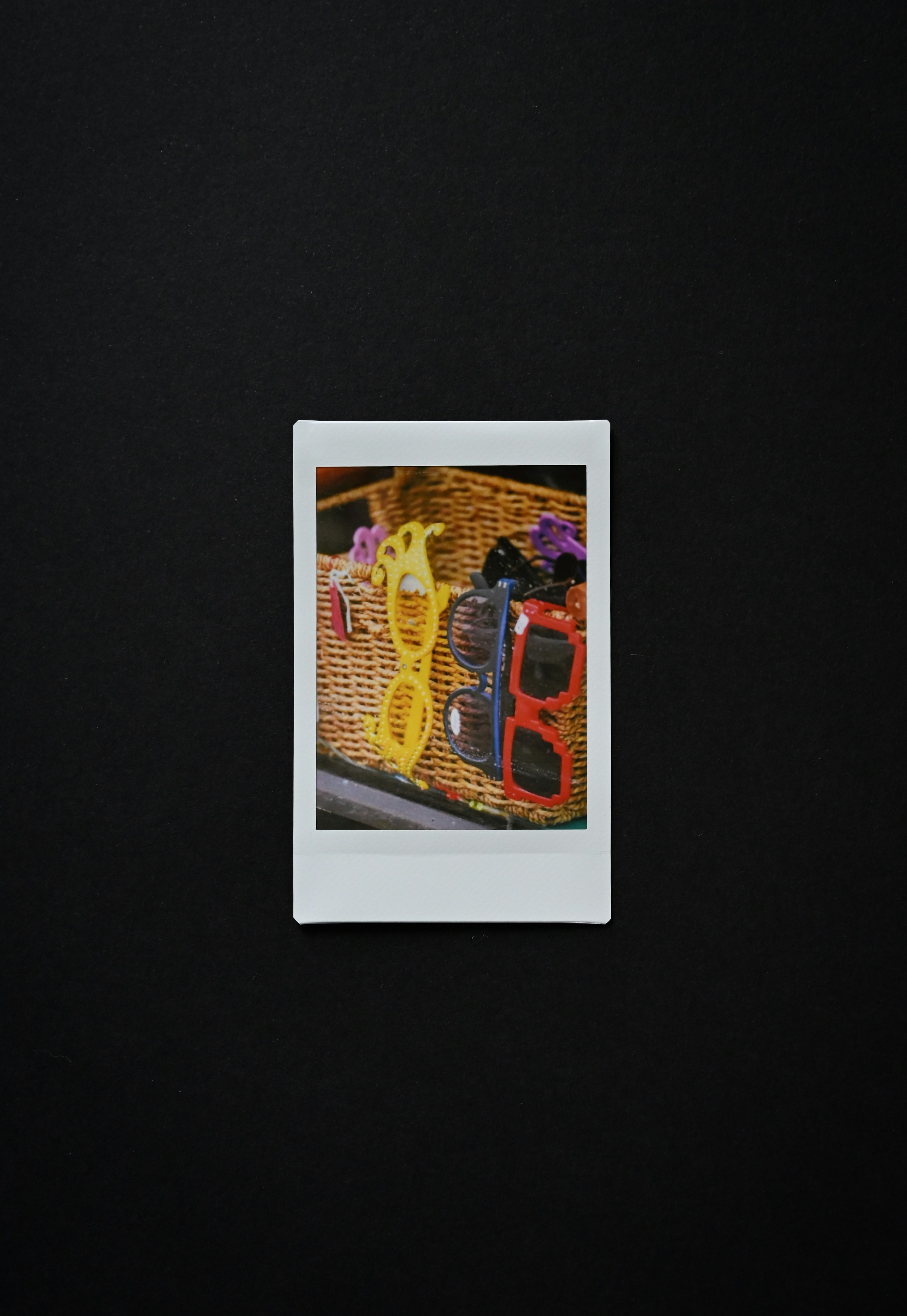 Two pairs of sunglasses in a woven basket.