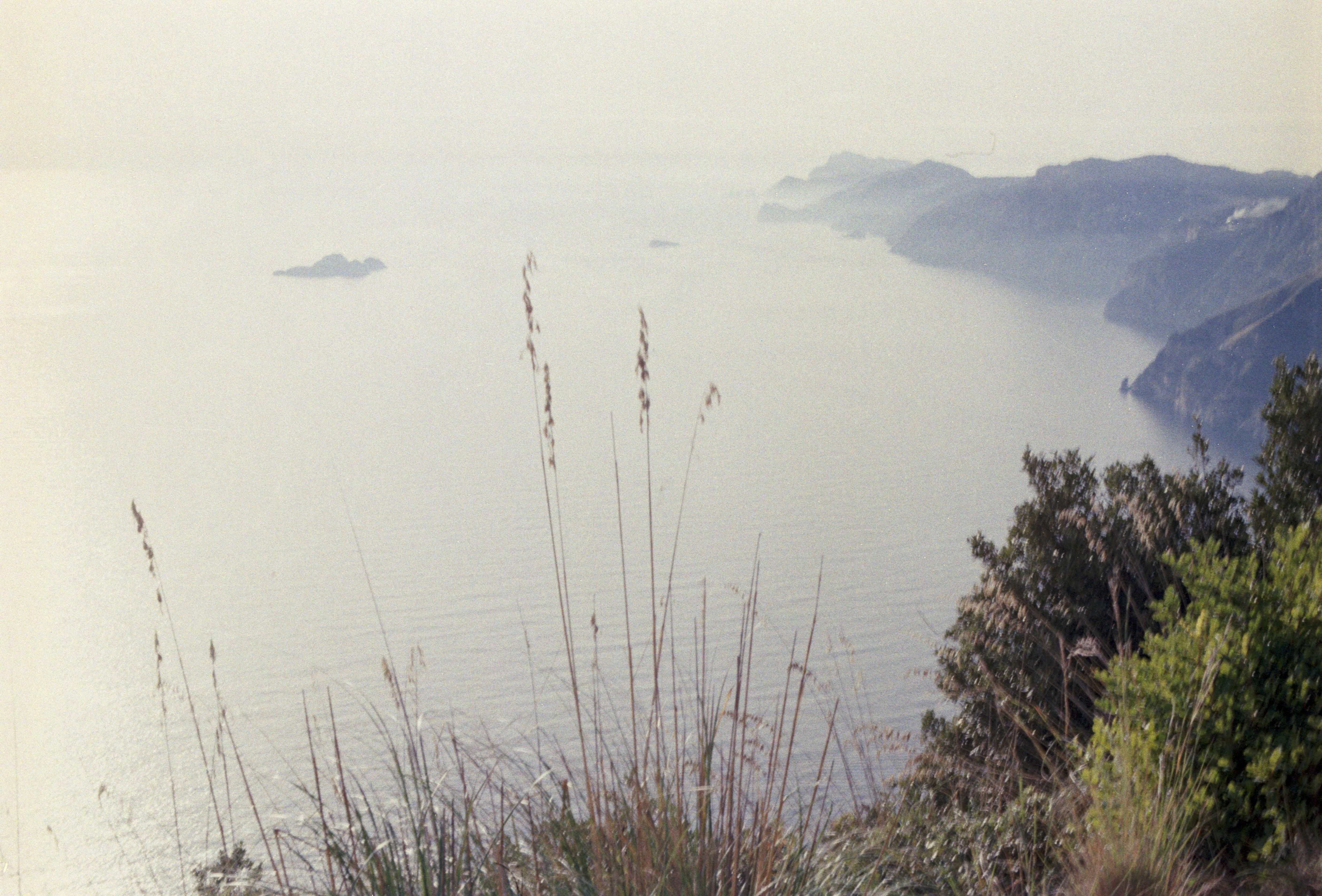 穏やかな海と遠くの丘陵地帯の海岸風景