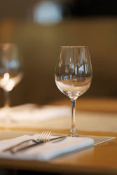 A wine glass and fork on a table setting