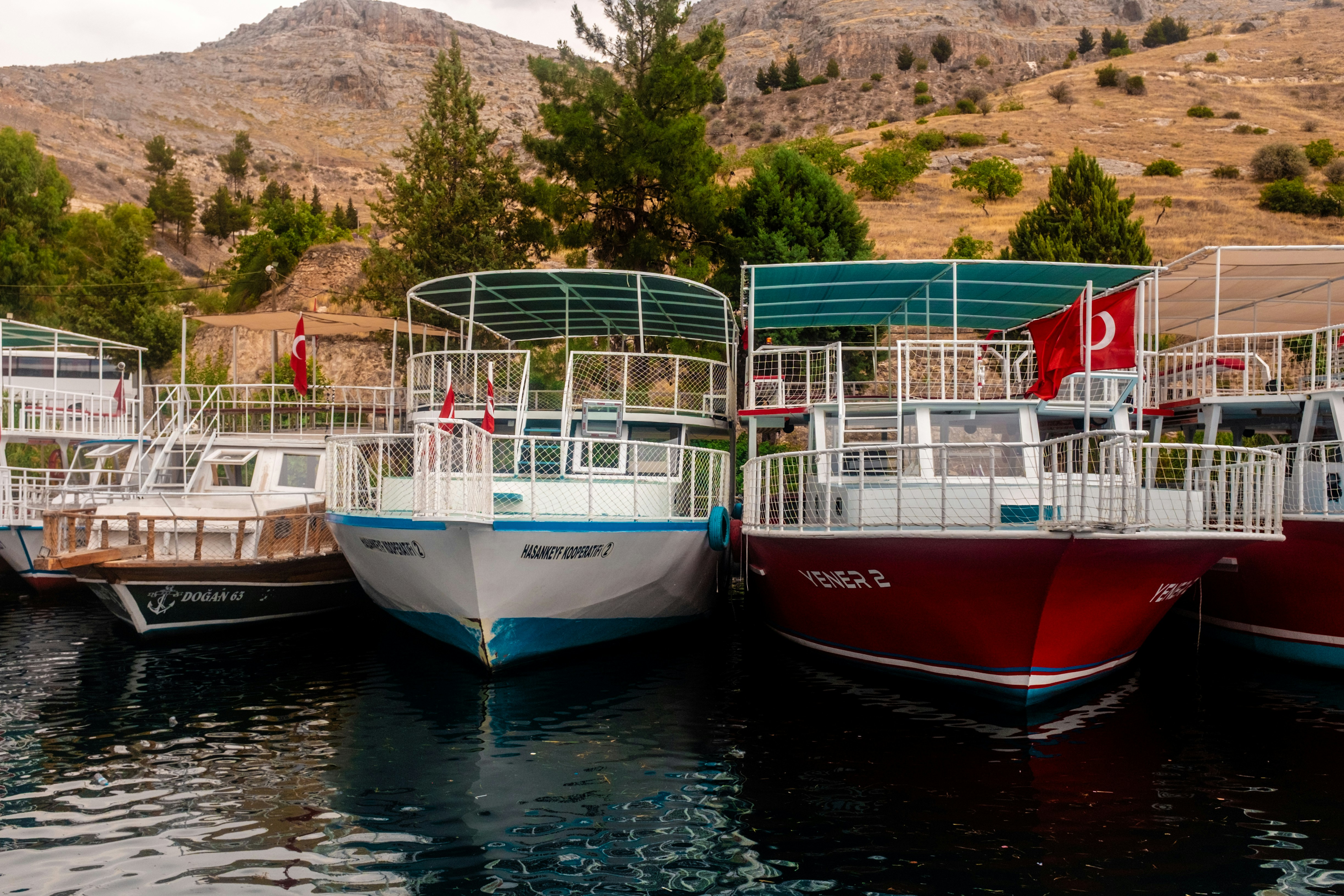 Several boats docked on a calm body of water.