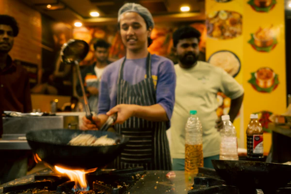 A chef cooking over a wok