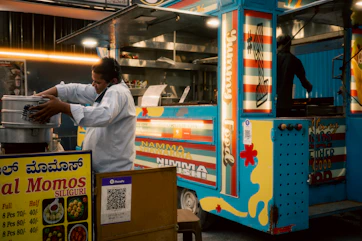 A person preparing food at a colorful food truck.