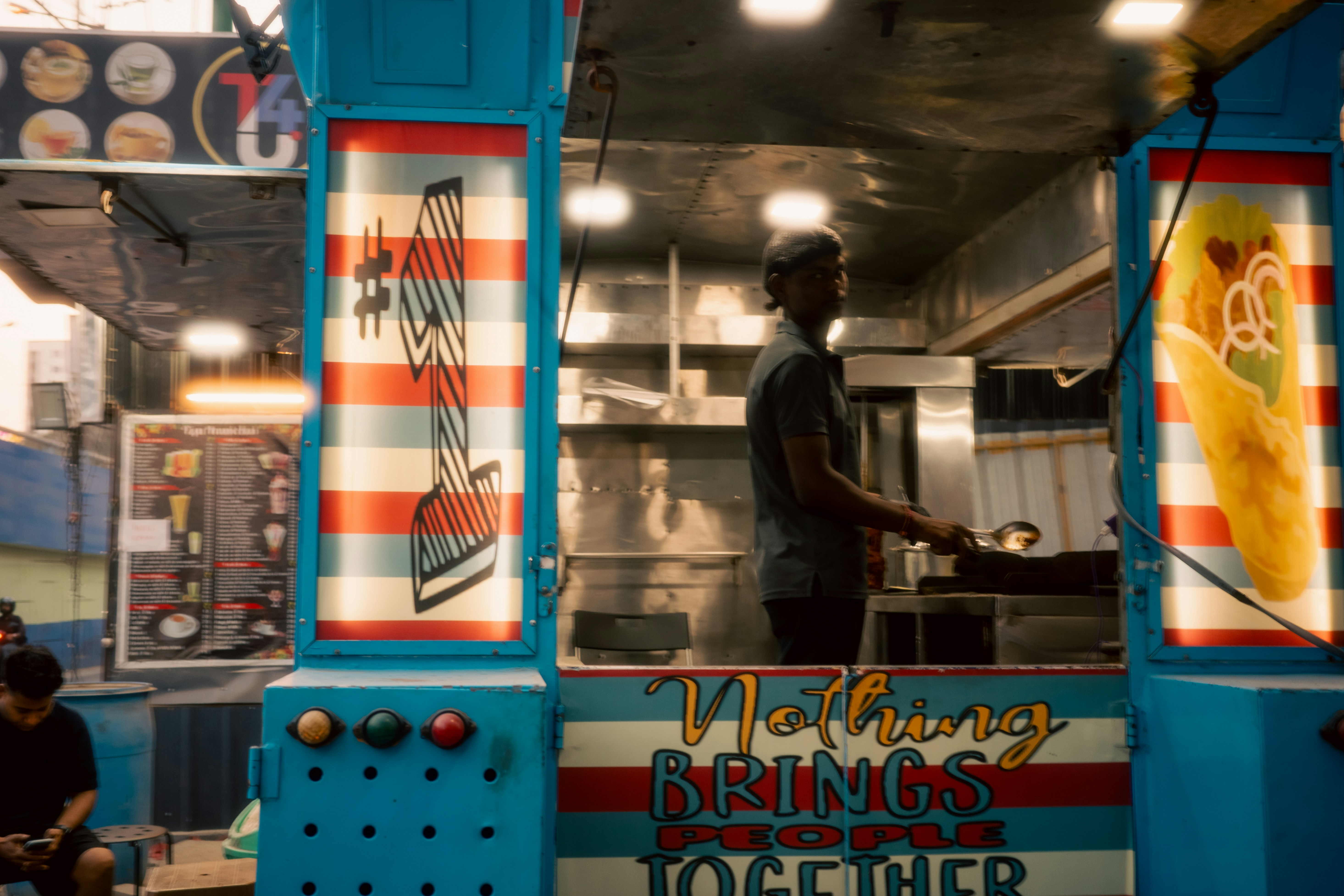 Uomo che lavora in un food truck colorato