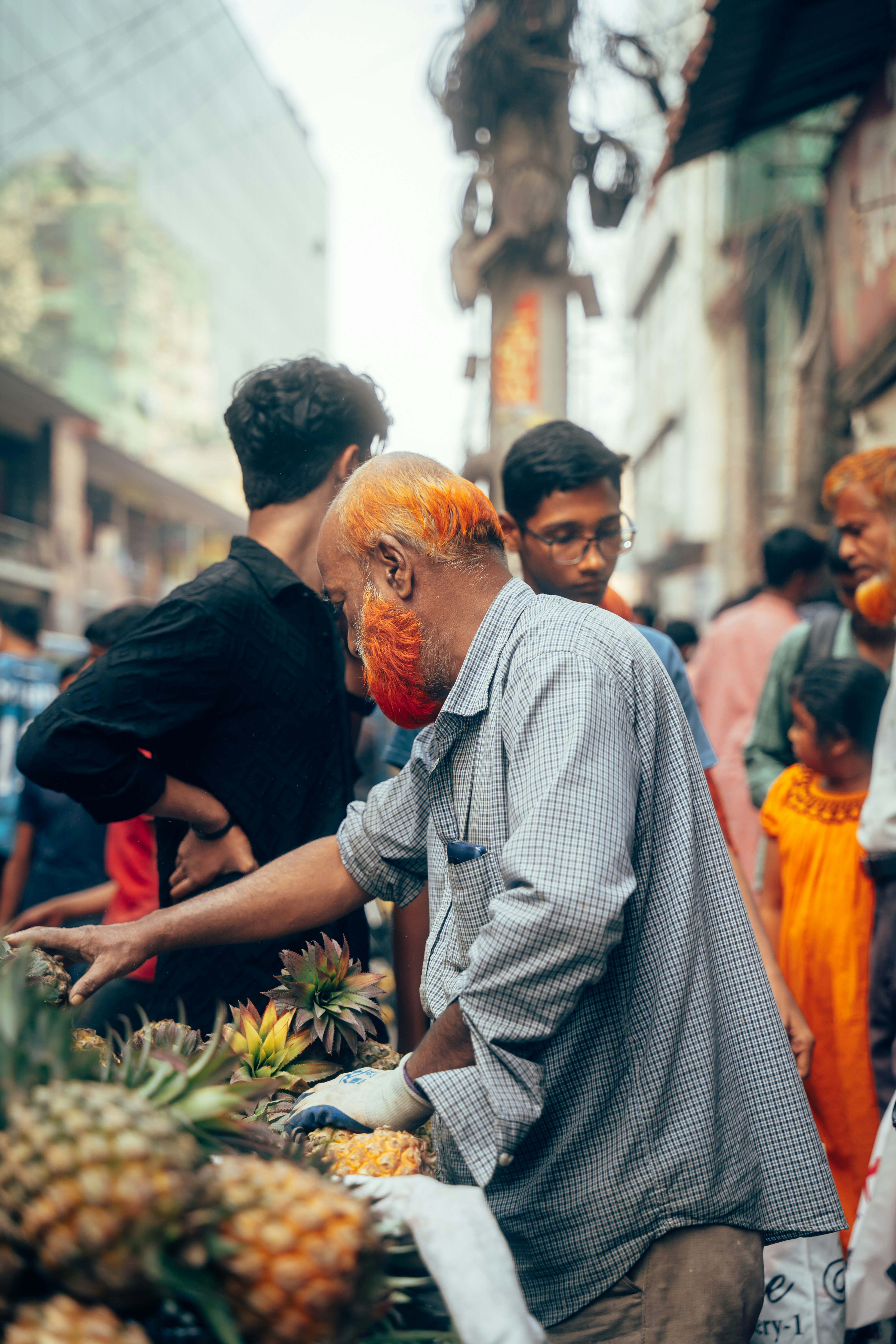 Mann mit orangefarbenen Haaren und Bart am Obststand