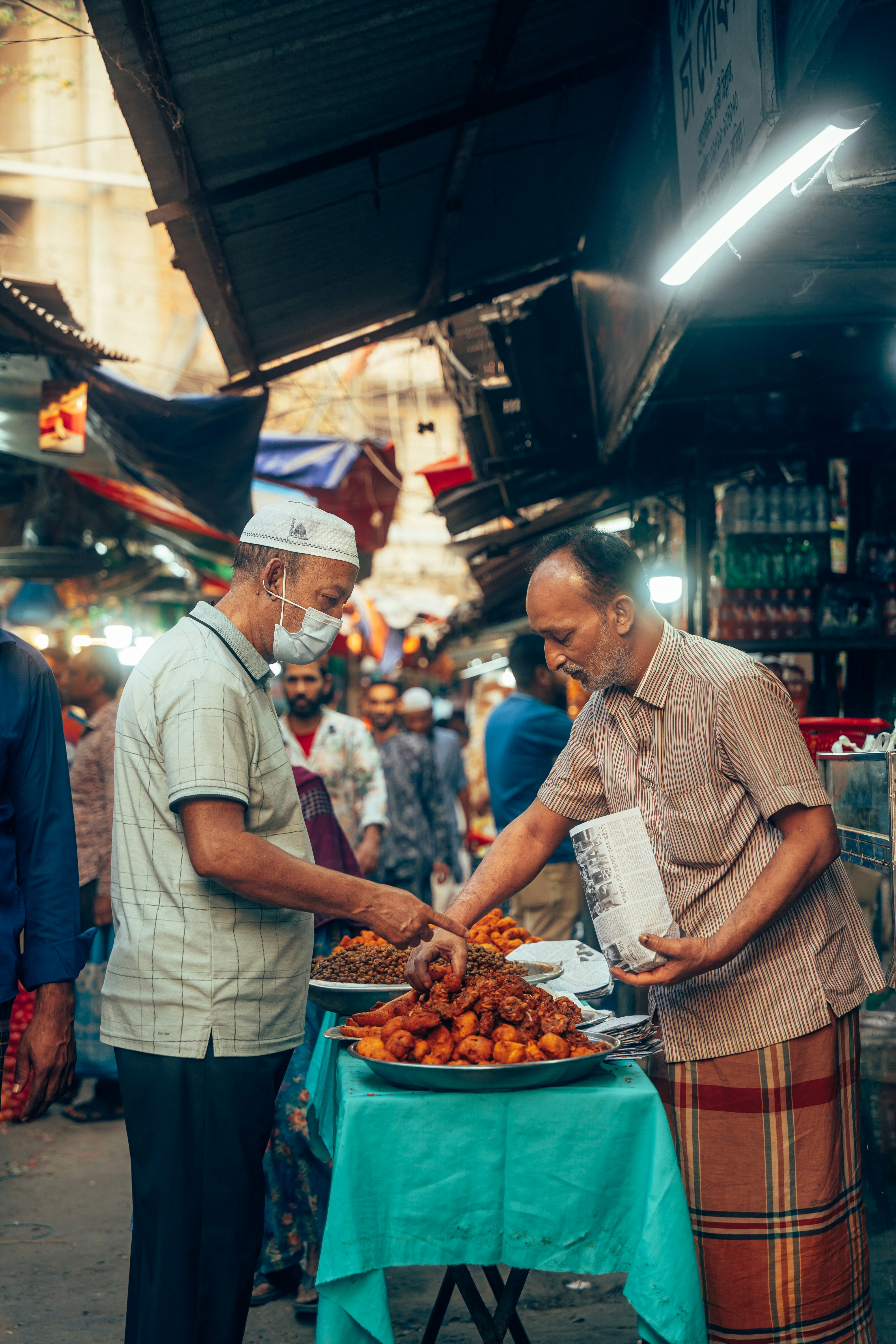 Zwei Männer an einem Marktstand mit Essen