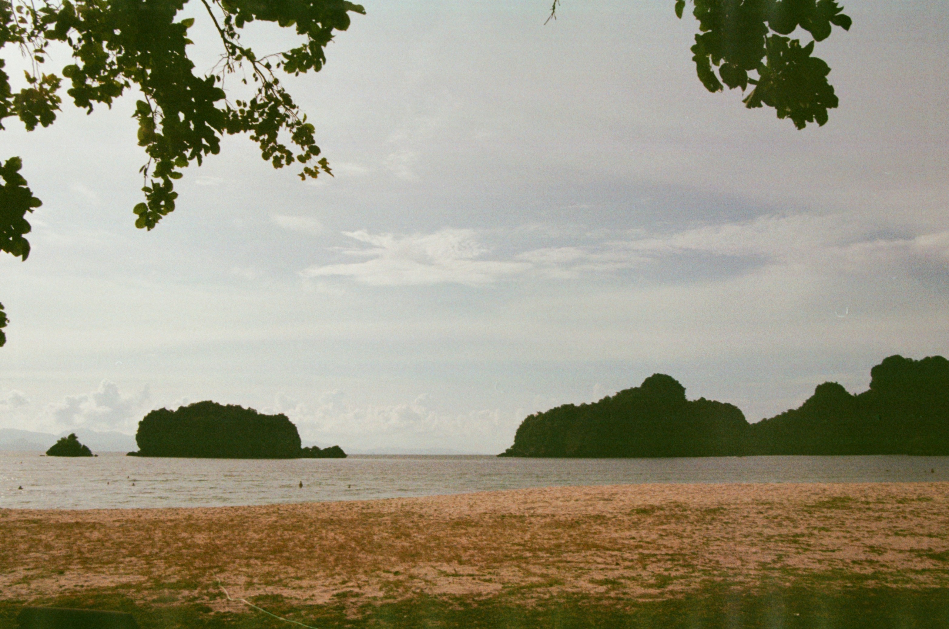 Tropical islands and calm ocean under a cloudy sky.