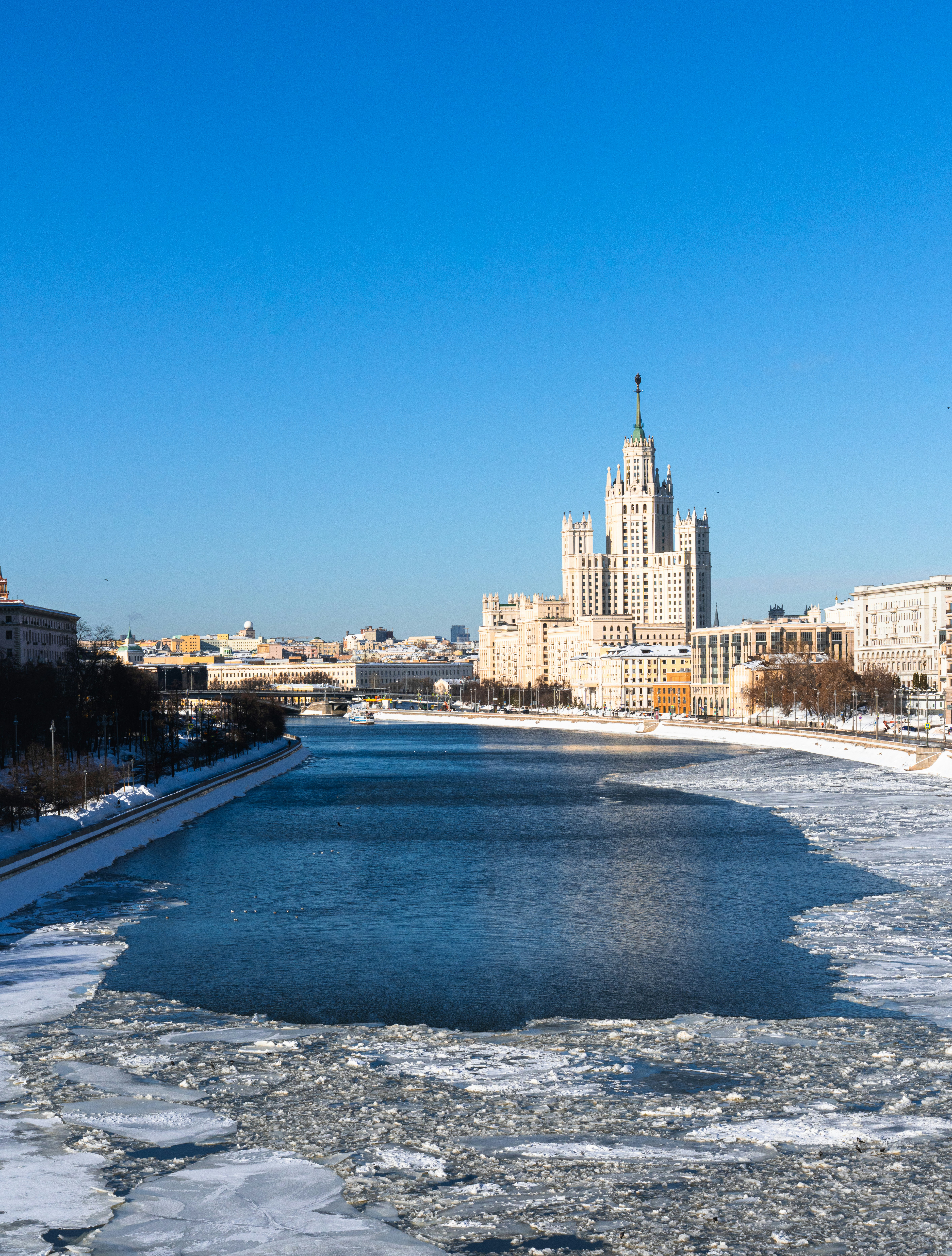 Frozen river with a tall building in the background.