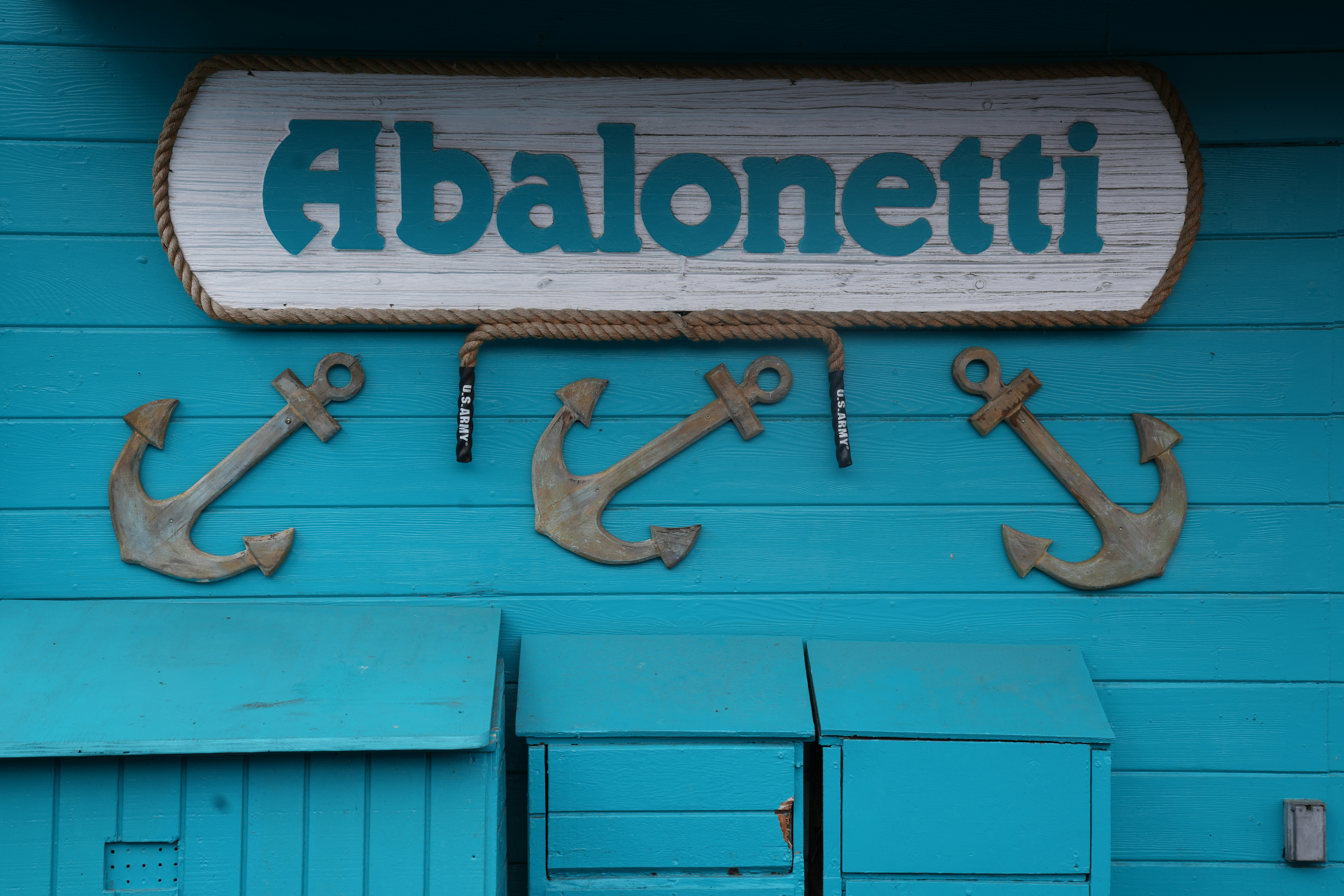 Abalonetti sign with anchors on blue wall