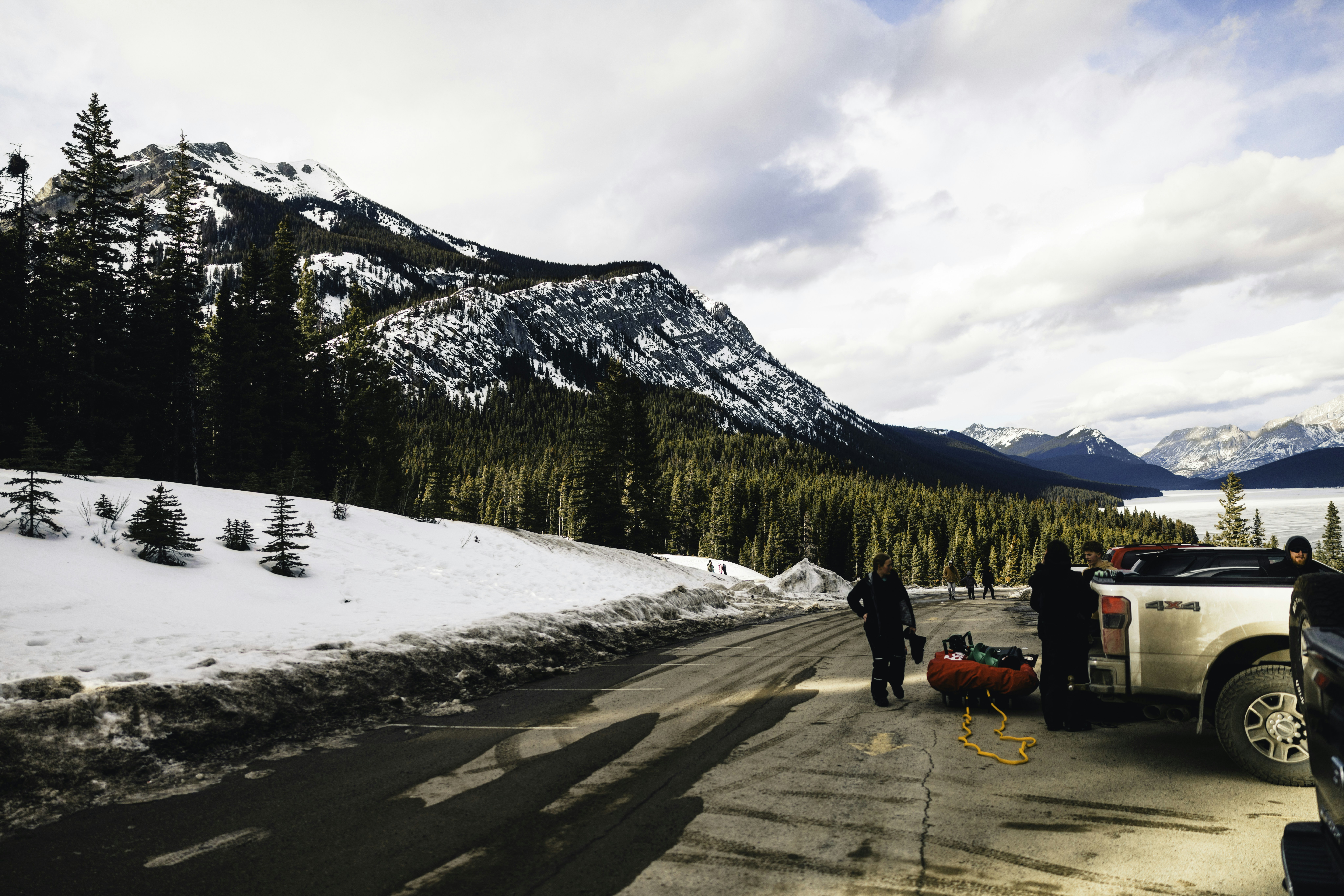 People with sled prepare for winter adventure near mountains