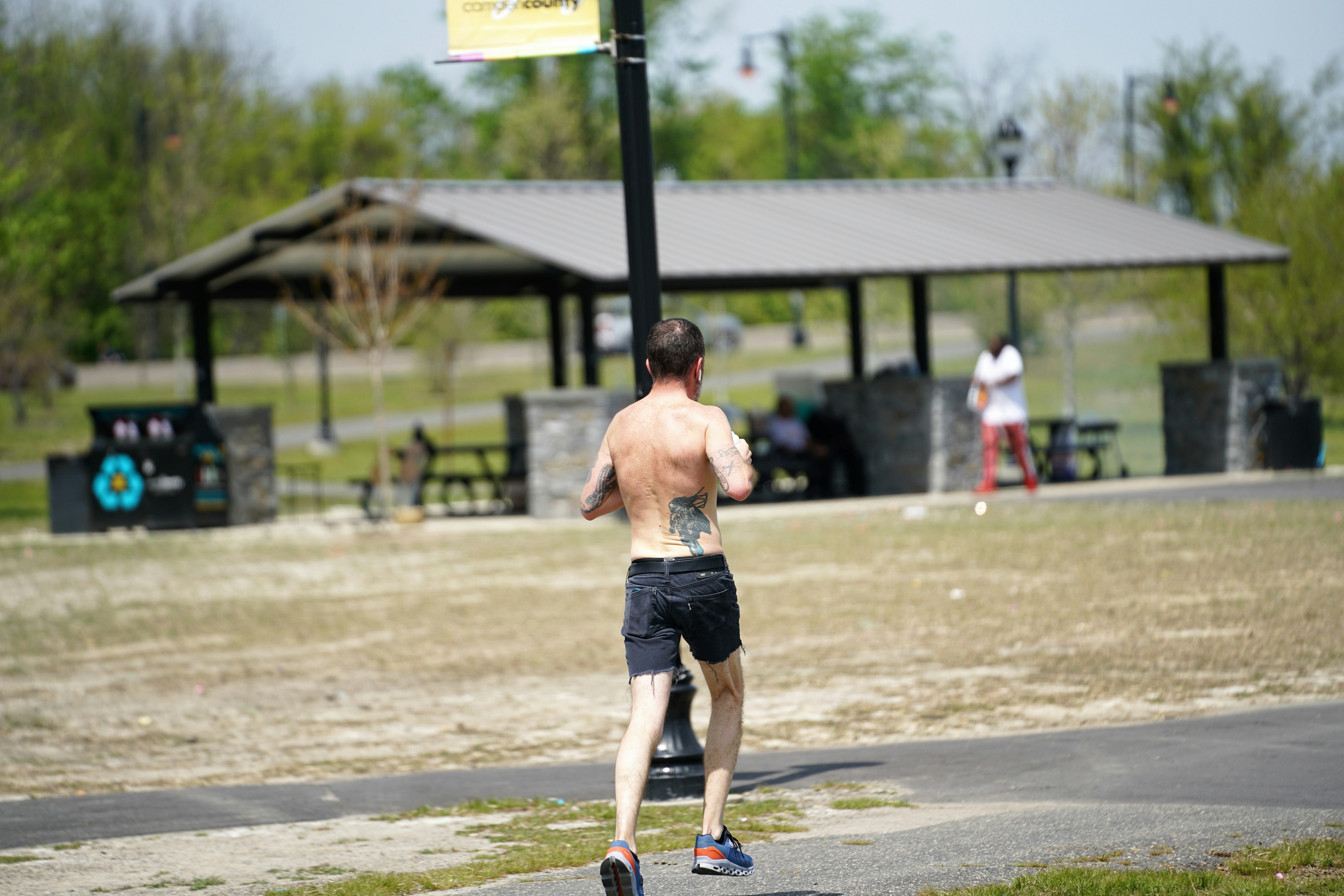 Man running on a path near picnic shelter