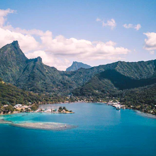 Tropical bay with lush green mountains and clear blue water.