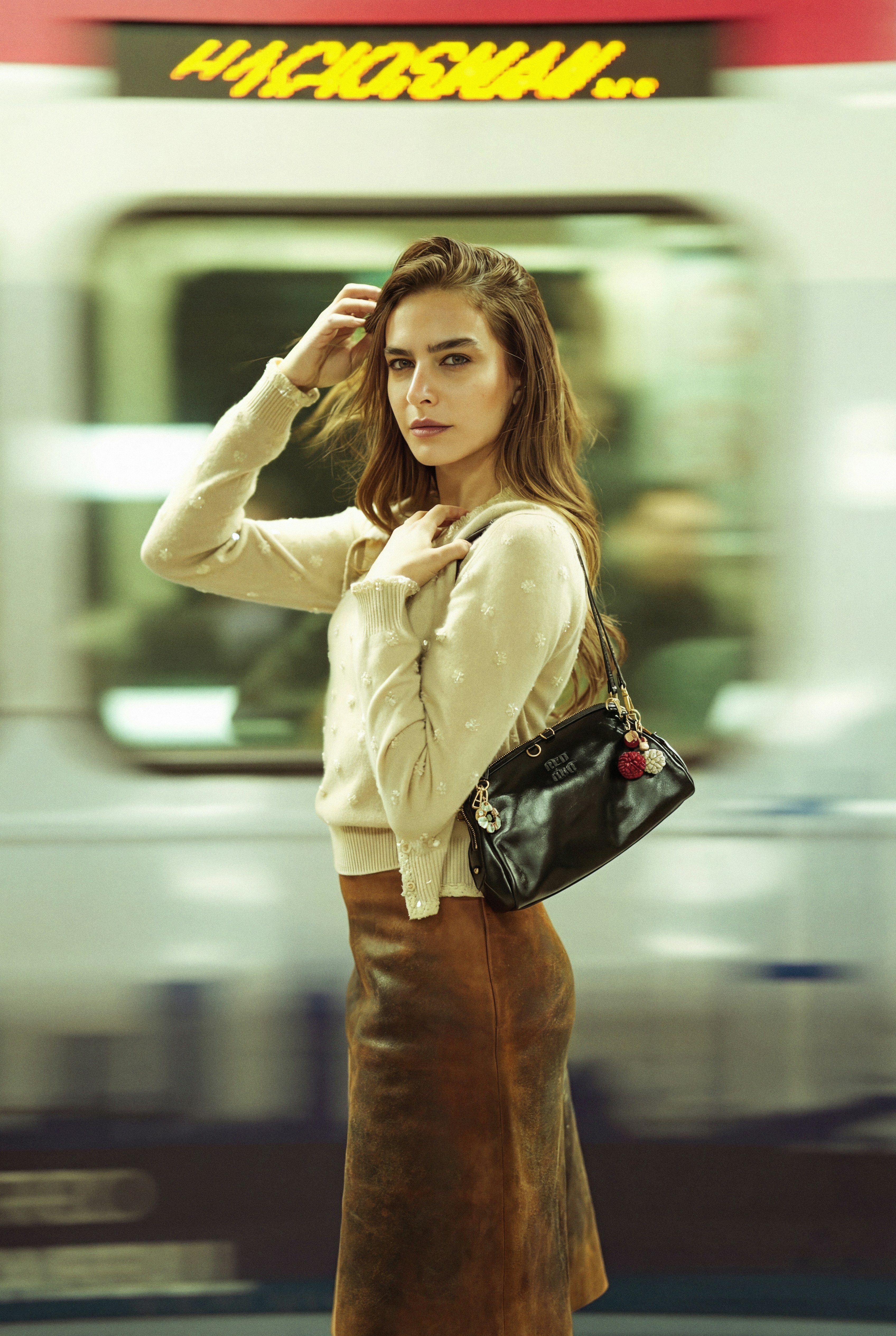Young woman with handbag at train station