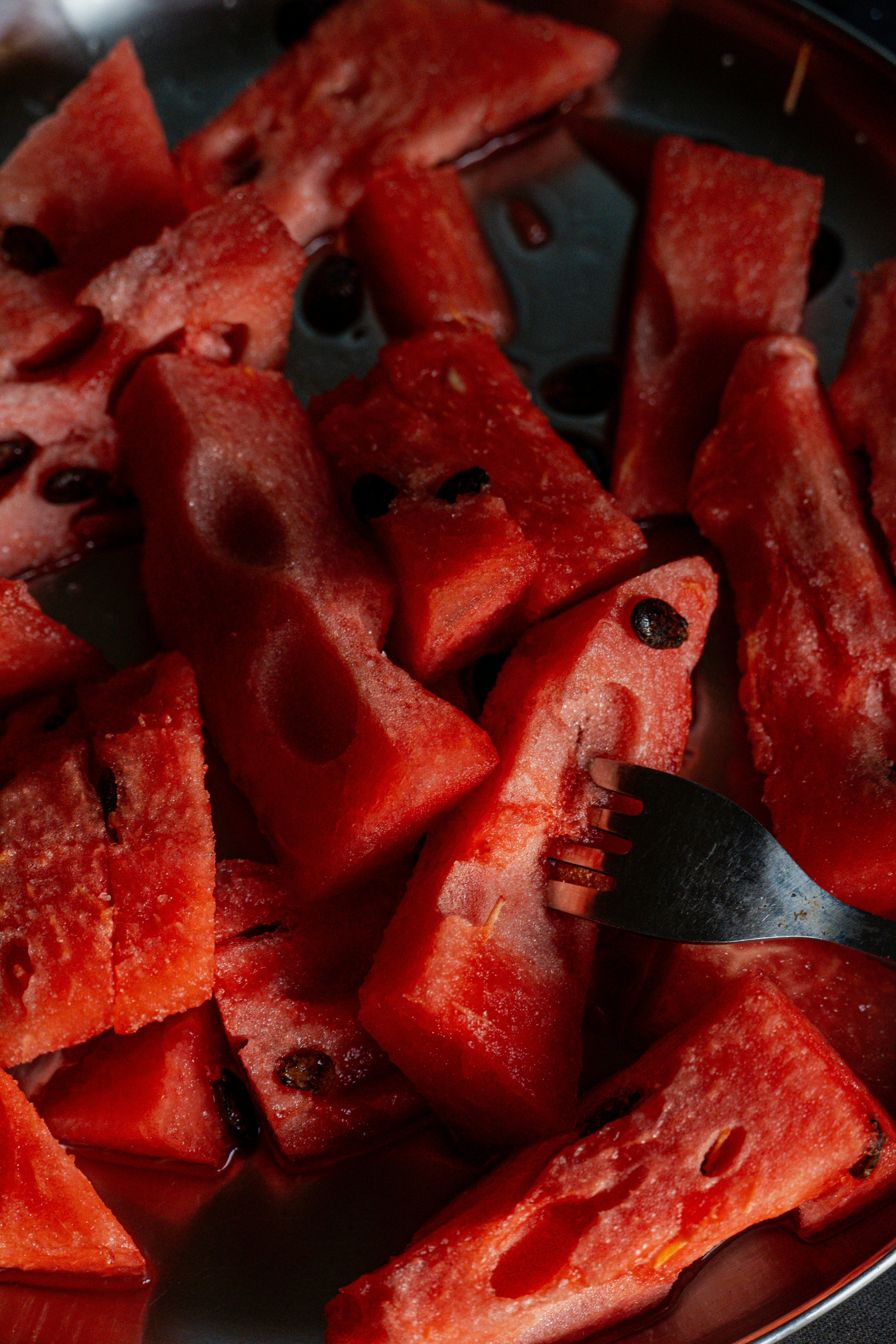 Scheiben frischer Wassermelone mit Samen auf einem Teller.