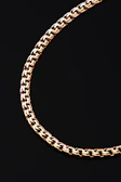 A close-up of a gold chain on black background